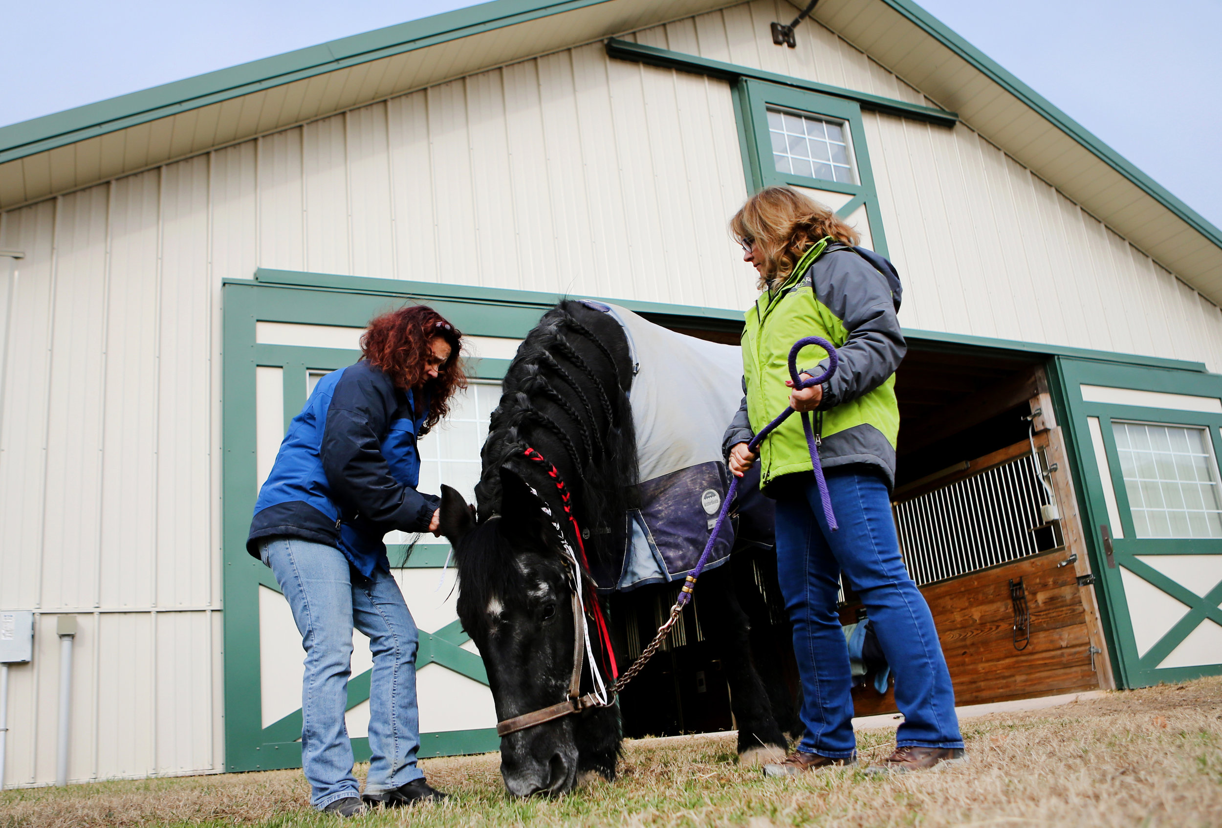 Roni DeCrescentis, left, and Susan Watkins spend time with "Sadie" outside of the barn one final time, Tuesday, Dec. 20, 2016 in Virginia Beach.