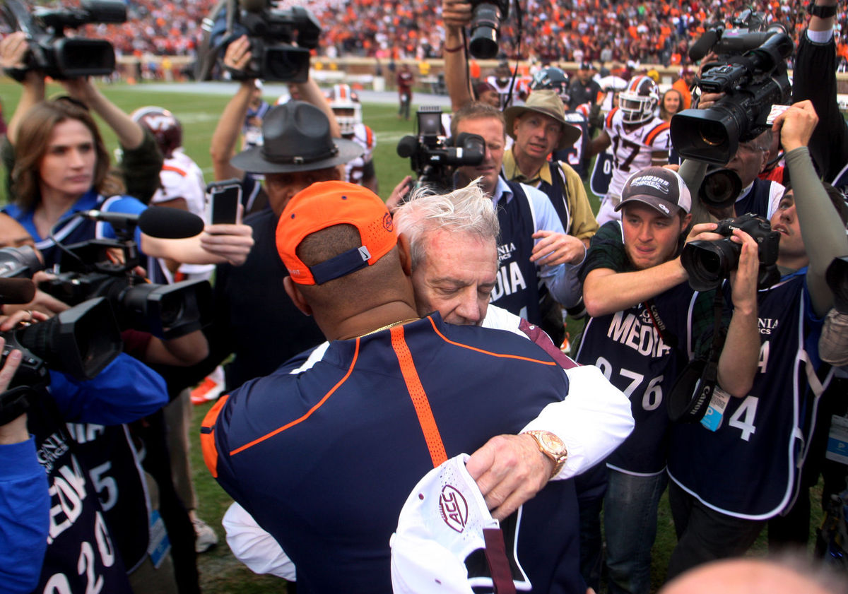 Virginia Tech head football coach Frank Beamer and University of Virginia coach Mike London embrace at midfield after the Hokie's beat the Cavaliers 23-20, Saturday, Nov. 15, 2015 in Charlottesville in what would be Beamer's last game with the in-state rivals as he retired at the end of the season. 