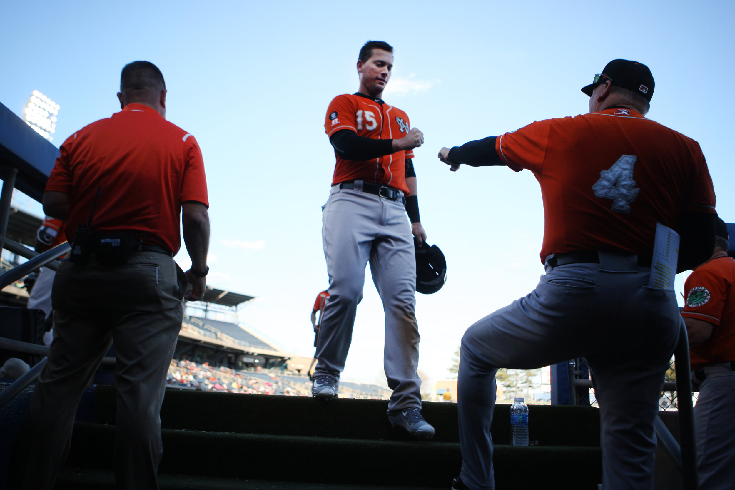 Tides third baseman Chris Johnson, center, fist bumps his father and manager Ron Johnson after popping out in an exhibition game against Norfolk State, Tuesday, April 4, 2017 at Harbor Park in Norfolk.