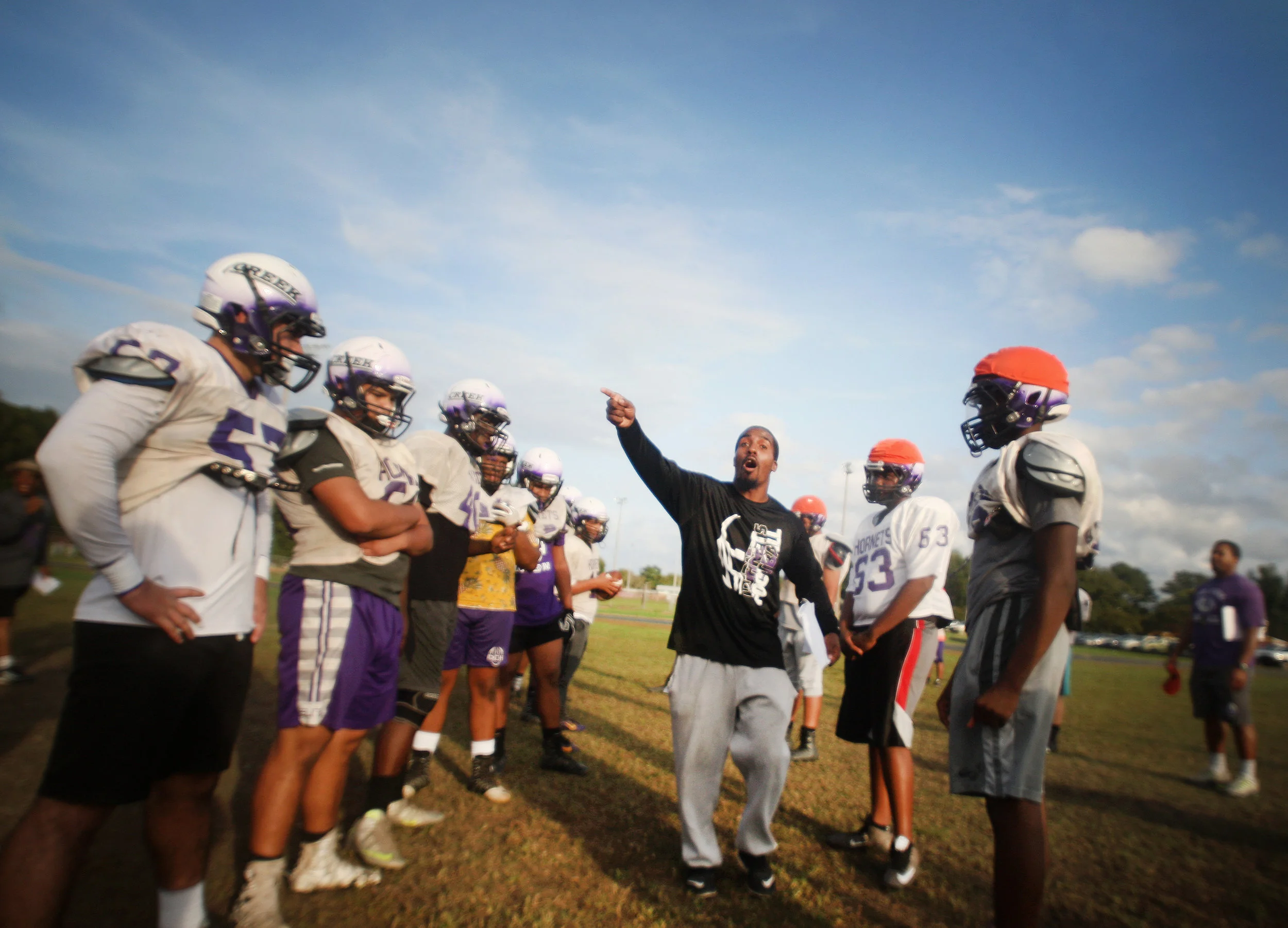 Deep Creek head coach Andre Twine talks with his team during practice, Monday, Oct. 9, 2017 at Deep Creek High School in Chesapeake. After nearly a decade in the basement, Twine has quickly turned things around for the Hornets program.