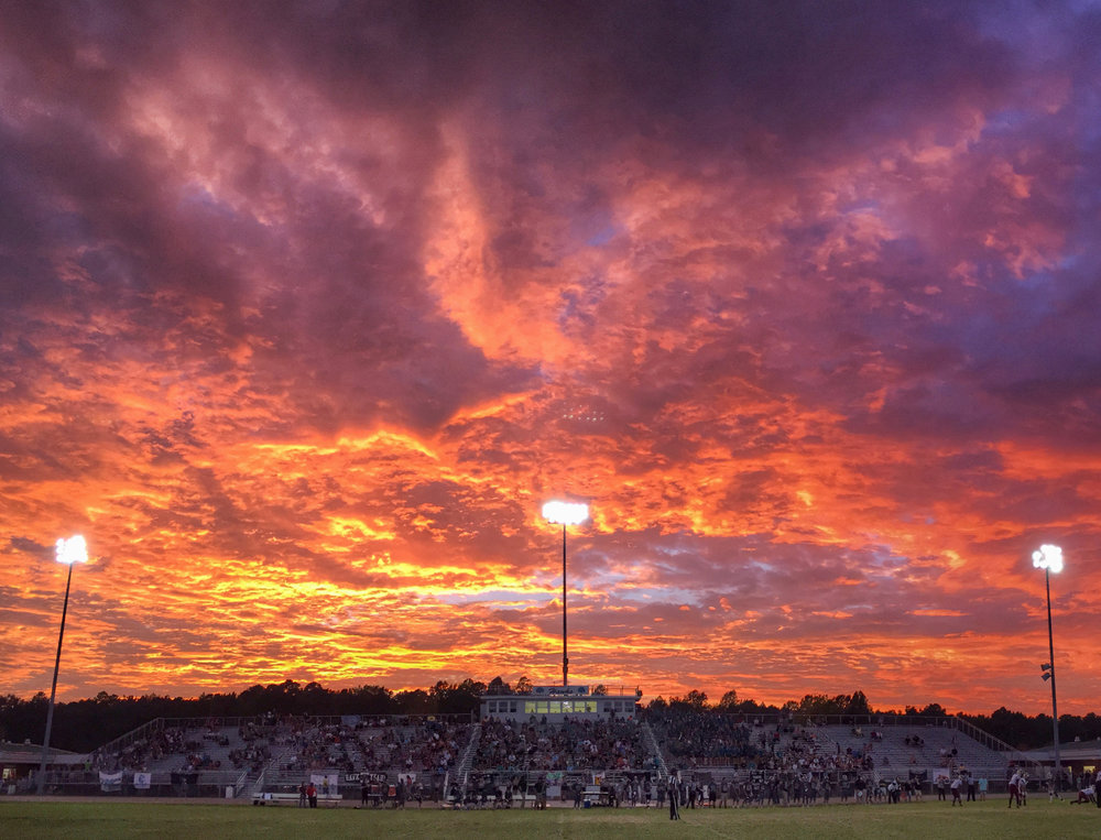 The sun sets during the King's Fork at Hickory football game.