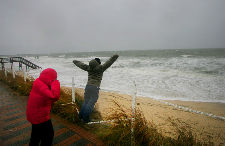Terrell Dwyer, 9, yelled "I'm the king of the world" as his sister Catherine Dwyer, left, shielded her eyes from the pounding surf brought by Hurricane Sandy along the Virginia coastline.