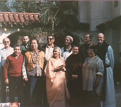 The 2nd Snowmass Conference at Ananda Ashram in La Crescenta, CA, 1985. Front Row: Swami Buddhananda, unknown observer, Gayatri Devi, Pema Chodron, Tania Lentov Back Row: unknown observer, Rabbi Rami Shapiro, Gerald Red Elk, Imam Bilal Hyde, Fr. George Timko, Fr. Thomas Keating OCSO. Photo by Roger La Borde.