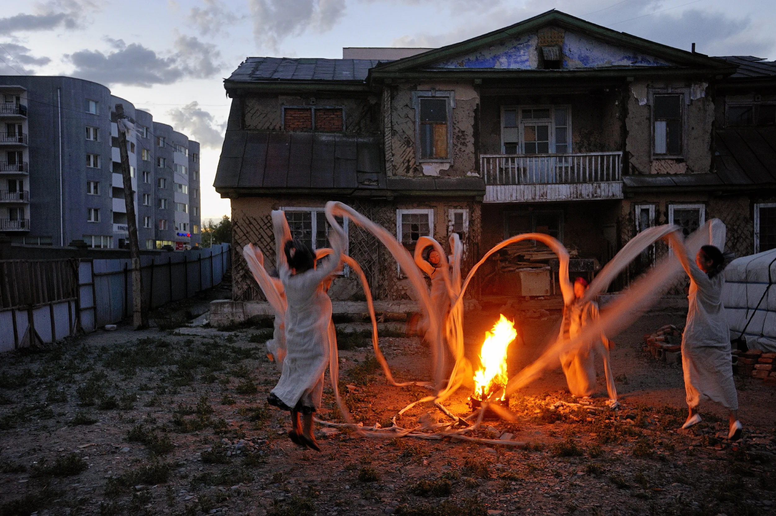  Nomad Wave women's art collective perform part of an installation piece at the former summer residence of Bogd Khan, the last emperor of Mongolia.   The linked sleeves of their garments represents unity and sisterhood, but also forms a ring of prote