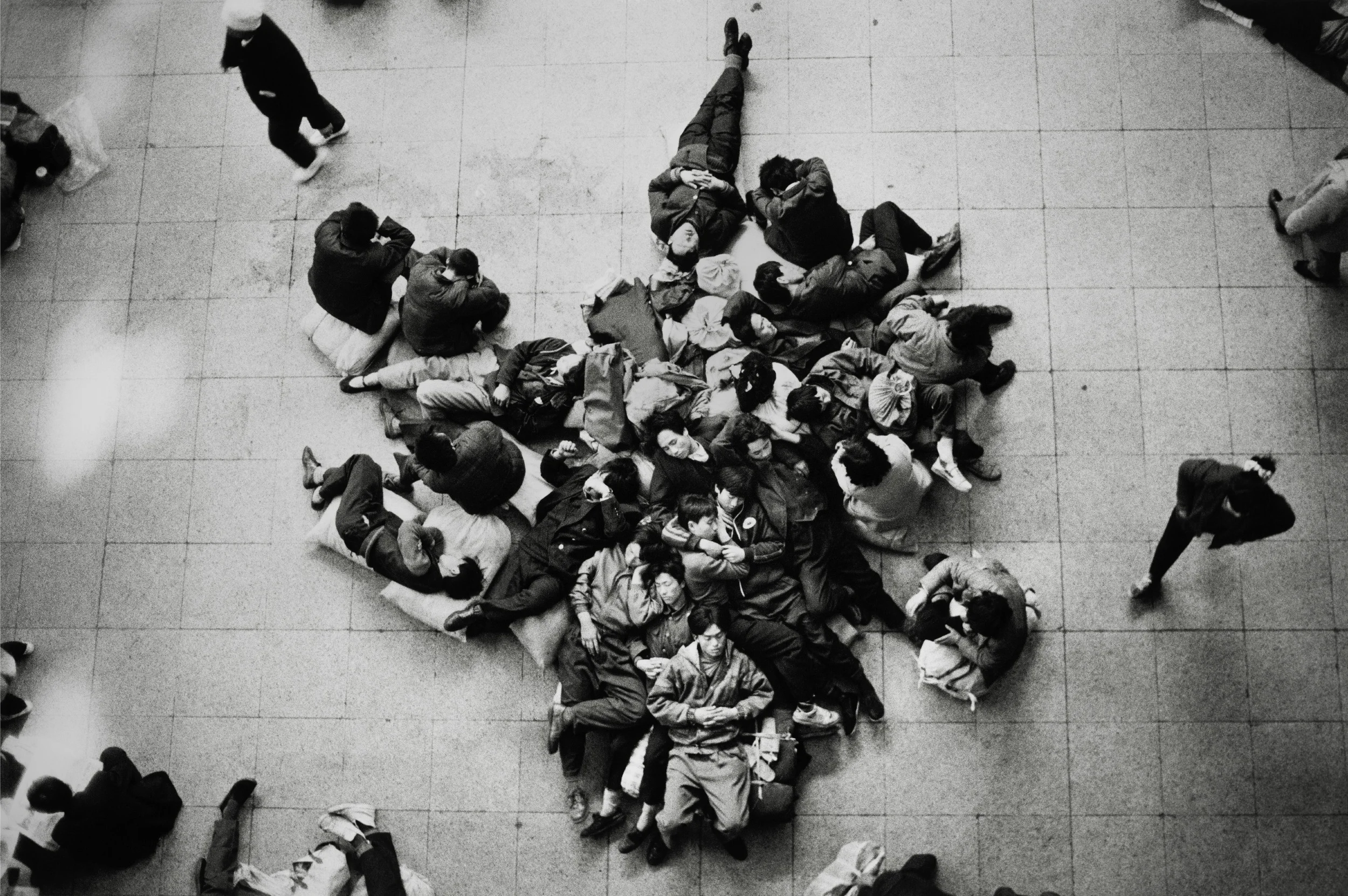  Beijing, 1992.  Migrant workers from the same provincial hometown doze in Beijing Station while some of their party are out looking for a construction site that will hire all of them 