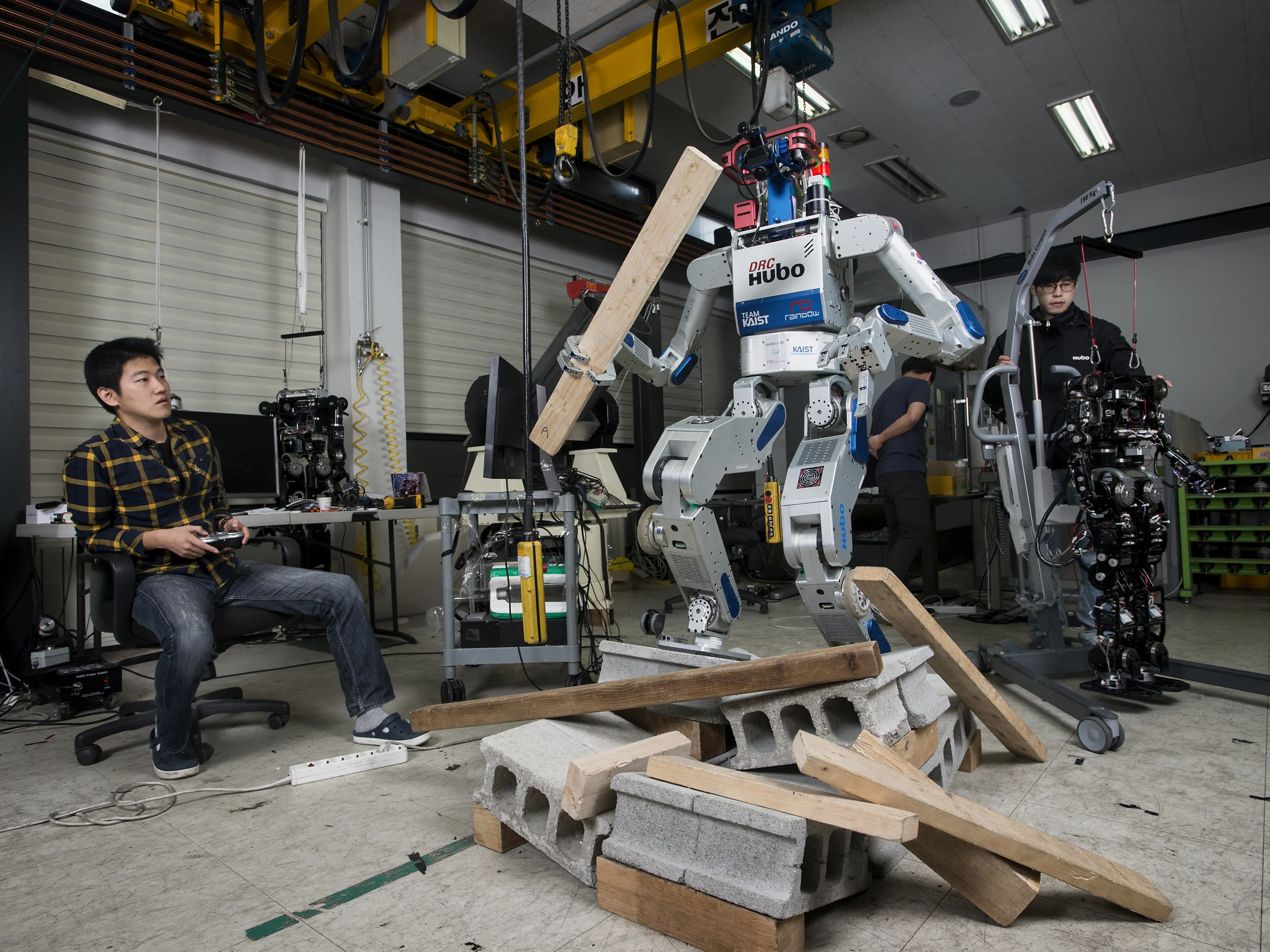  Seoul, 2016.  Graduate students at KAIST (Korea Advanced Institute of Science and Technology) Hubo Lab work with various generations of their robot, including the 2015 DARPA Robotics Challenge champion DRC-Hubo  