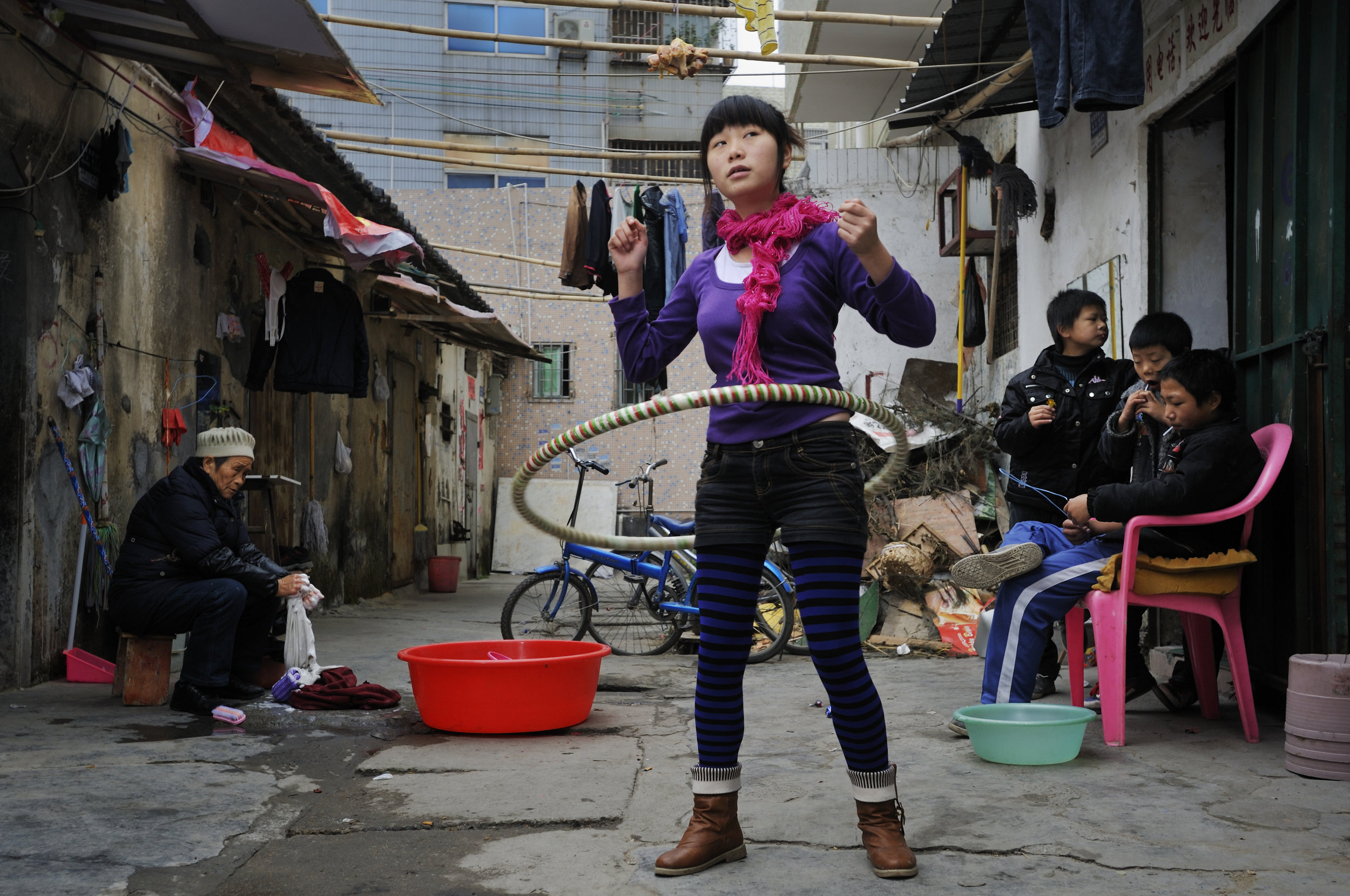  Shenzhen, 2010.  Tan Yue, like virtually every woman in her urban village, works at the New Balance factory about a mile away.   She hula hoops during the Lunar New Year holiday break 