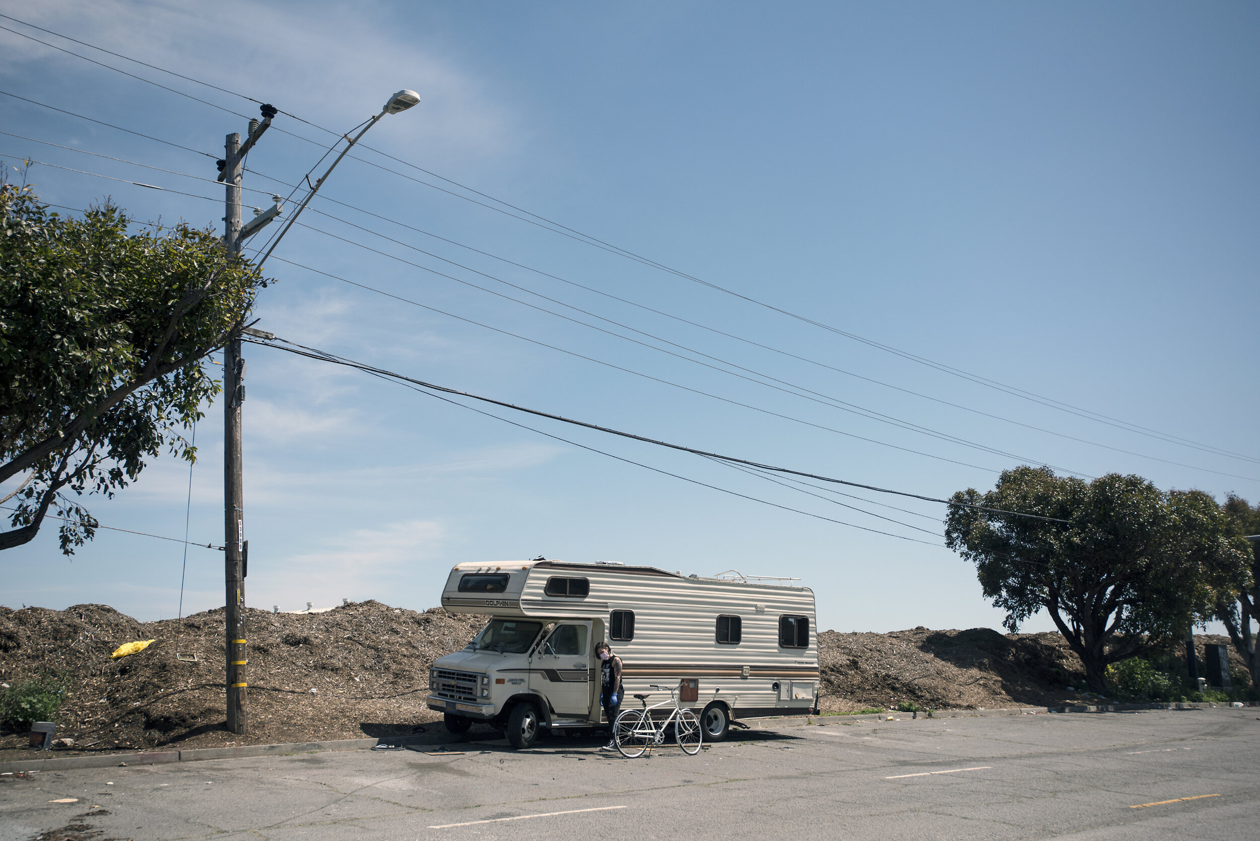  A, a member of the GLIDE outreach team, drops off food, supplies and tents throughout San Francisco, including isolated dwellings like this mobile home near Candlestick Park. 