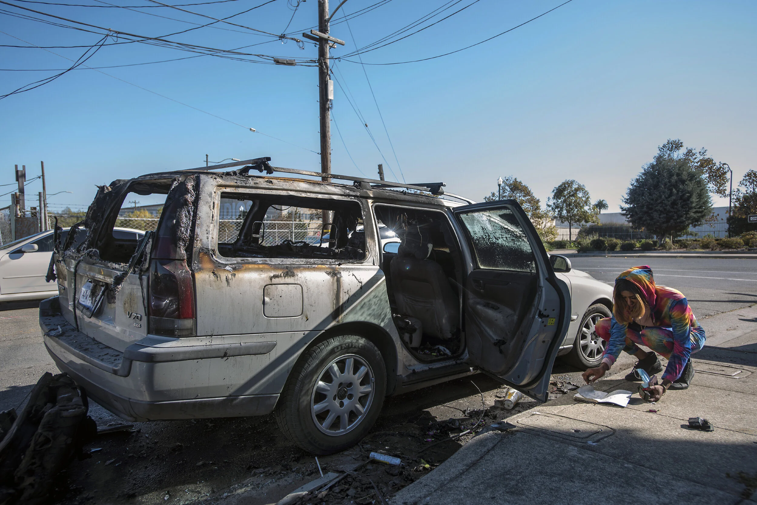  J was living out of her car parked on a residential Oakland street but was luckily not home when a former boyfriend torched the vehicle and most all of her belongings.  She flips through a notebook as she tries to salvage other items from the charre