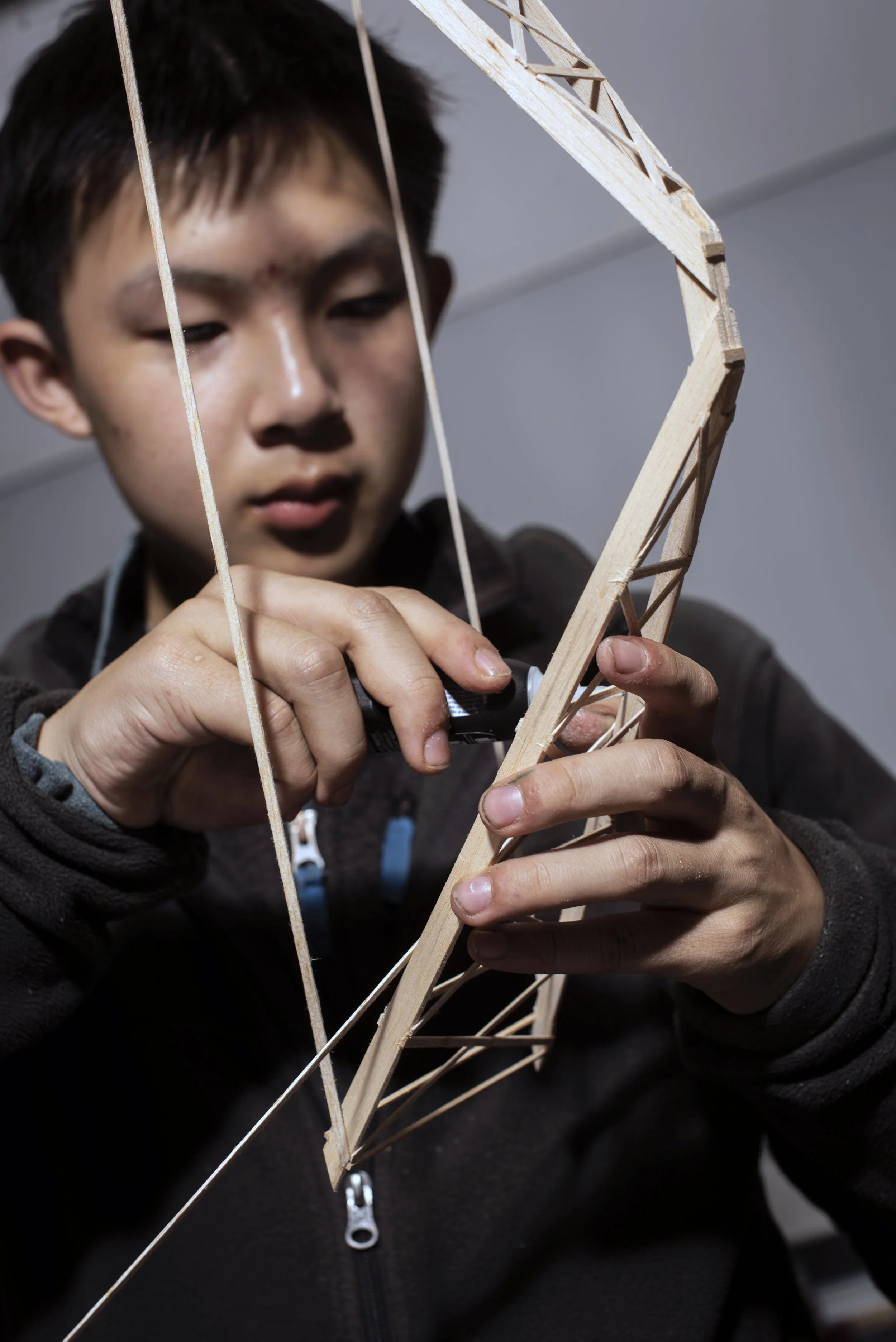  Mountain View, 2023.  Member of Mountain View High School Science Olympiad Team constructs a bridge out of balsa and basswood.  Only about 8 grams, it is designed to support up to 15 kilograms in competition 