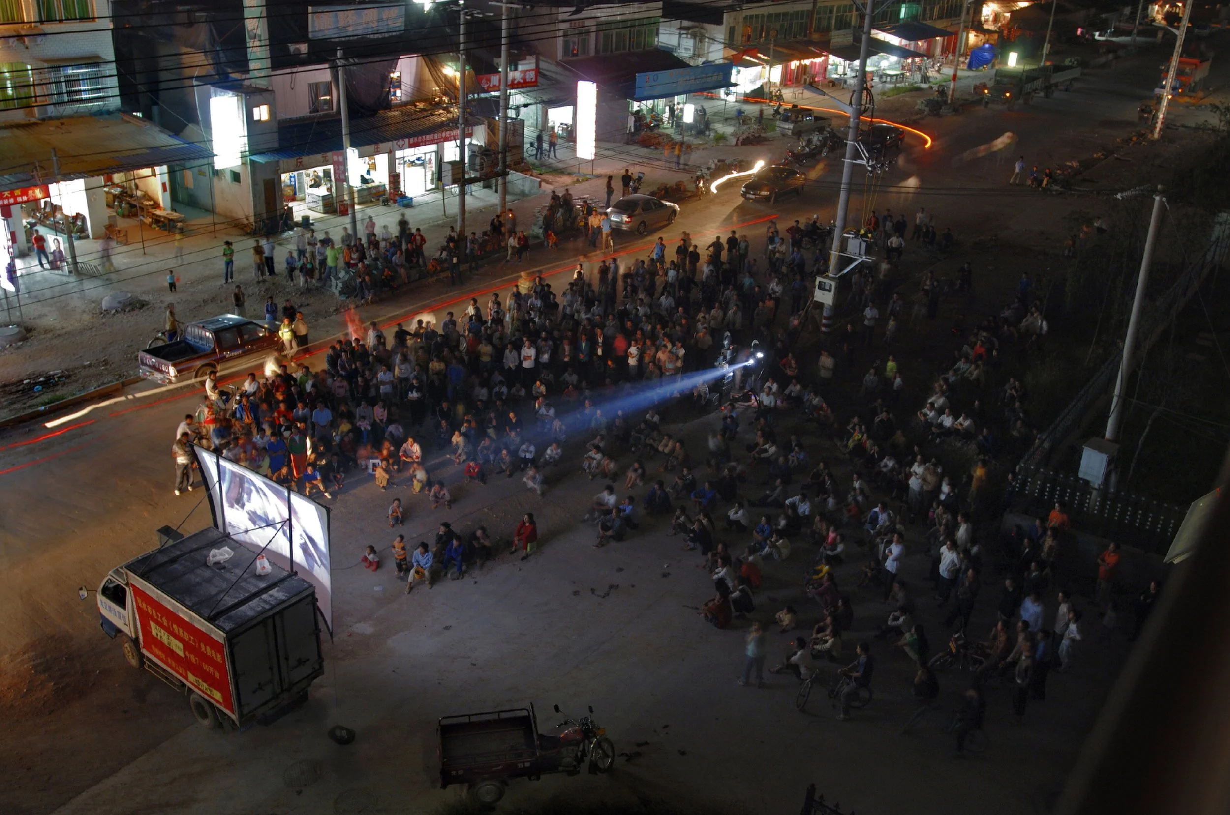  Lishui, 2006.  On the barely finished streets of this Zhejiang industrial boomtown, there is very little for the factory and construction workers to do at night except watch free outdoor screenings of action movies  