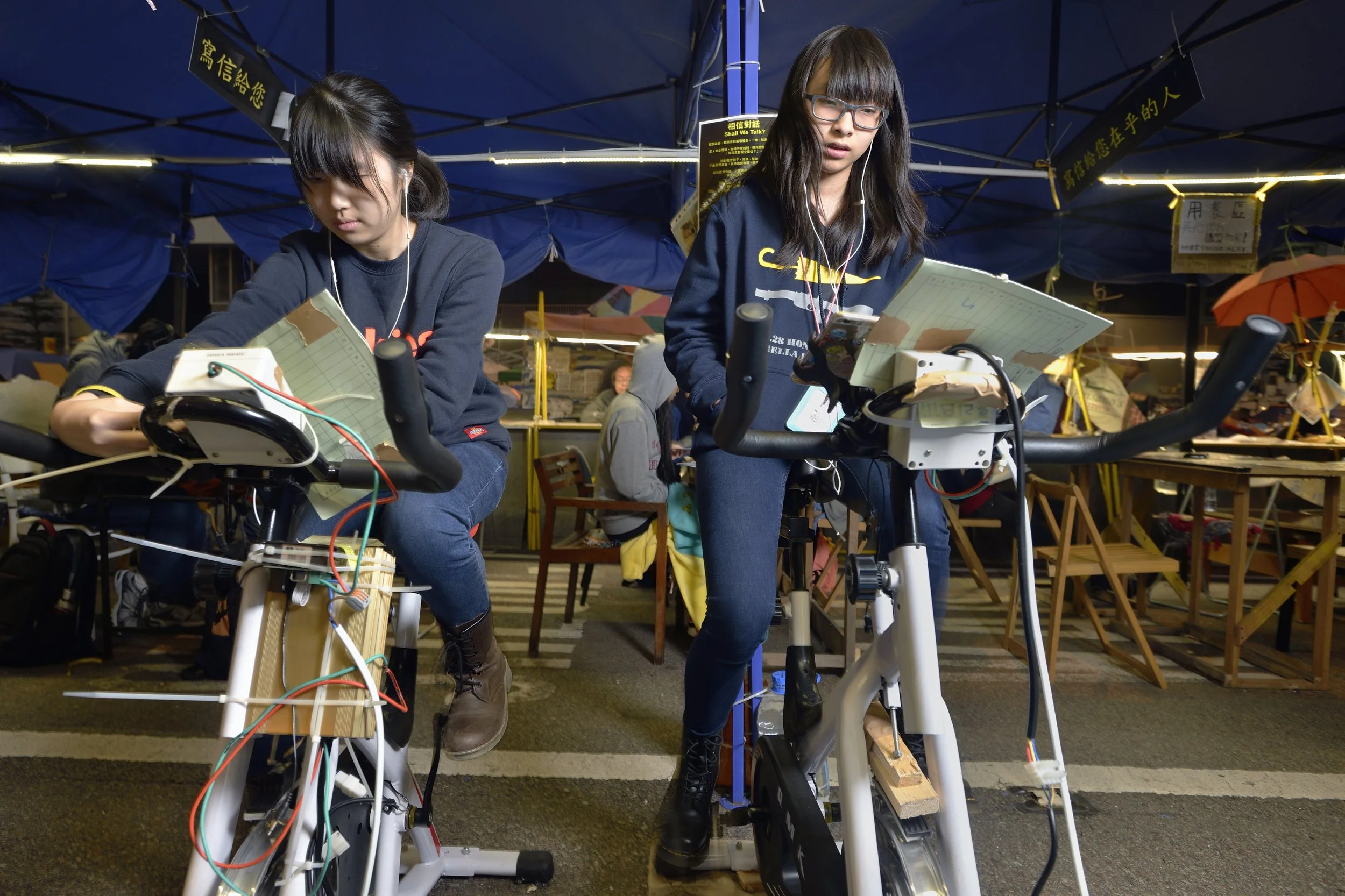  Hong Kong, 2014. The three month Occupy Central protest by the student-led pro-democracy Umbrella Movement included a "study hall" tent to allow students to continue their exam preparation while protesting.  These middle schoolers took shifts riding