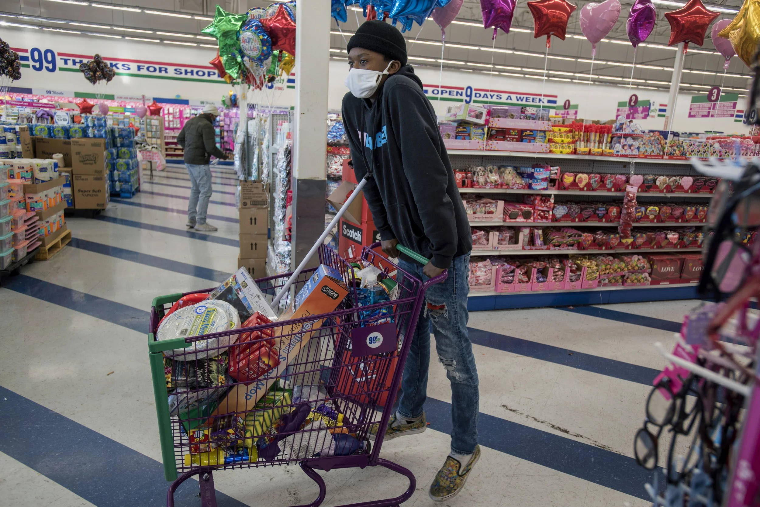  14 year-old K waits for his mother T in line at the 99 Cents Only Store in Richmond. They are buying food and cleaning supplies for themselves others in their city-provided shelter. They have been bouncing around different hotel rooms and shelters s