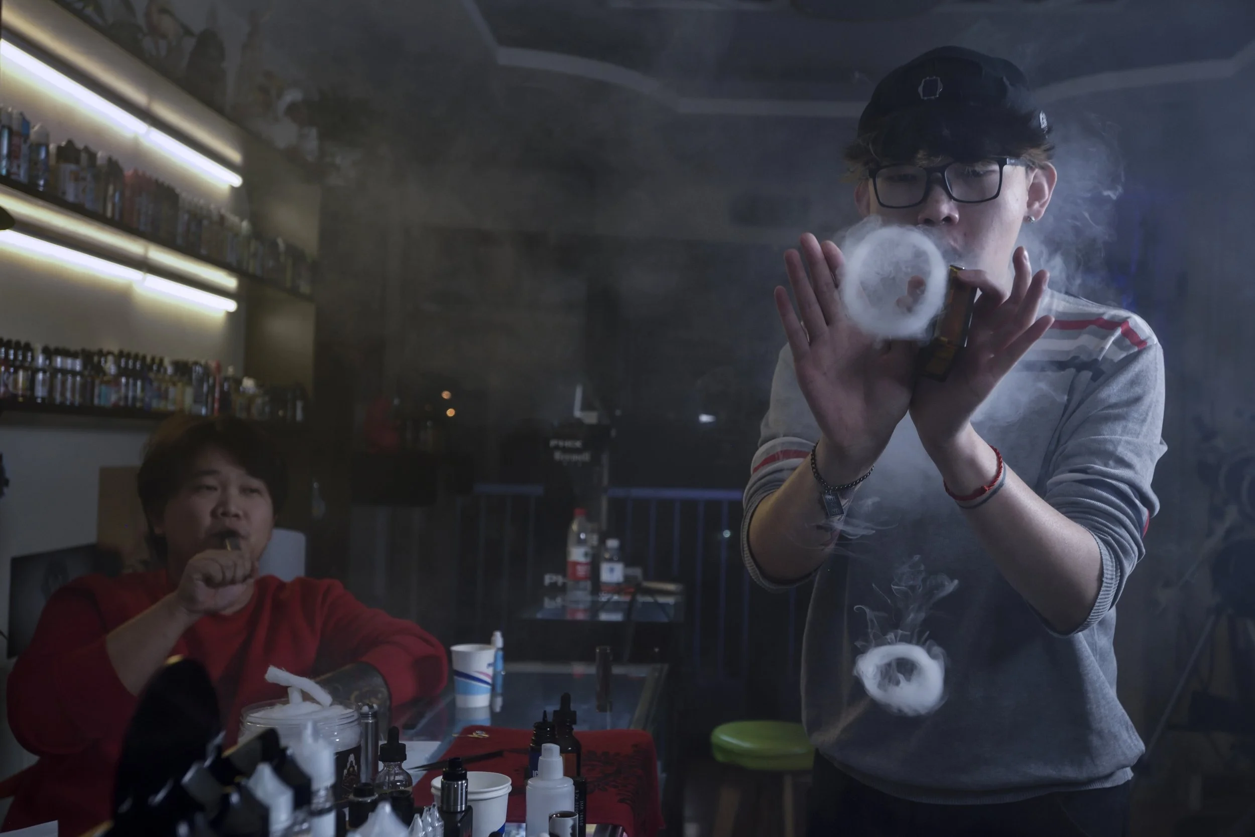   China Youth . Beijing, 2018. Smoking hobbyists run a vape shop. One common characteristic in young Chinese is the immediate desire to monetize their hobbies. Within two years of this photo, they had both moved on to 3 or 4 other ventures 