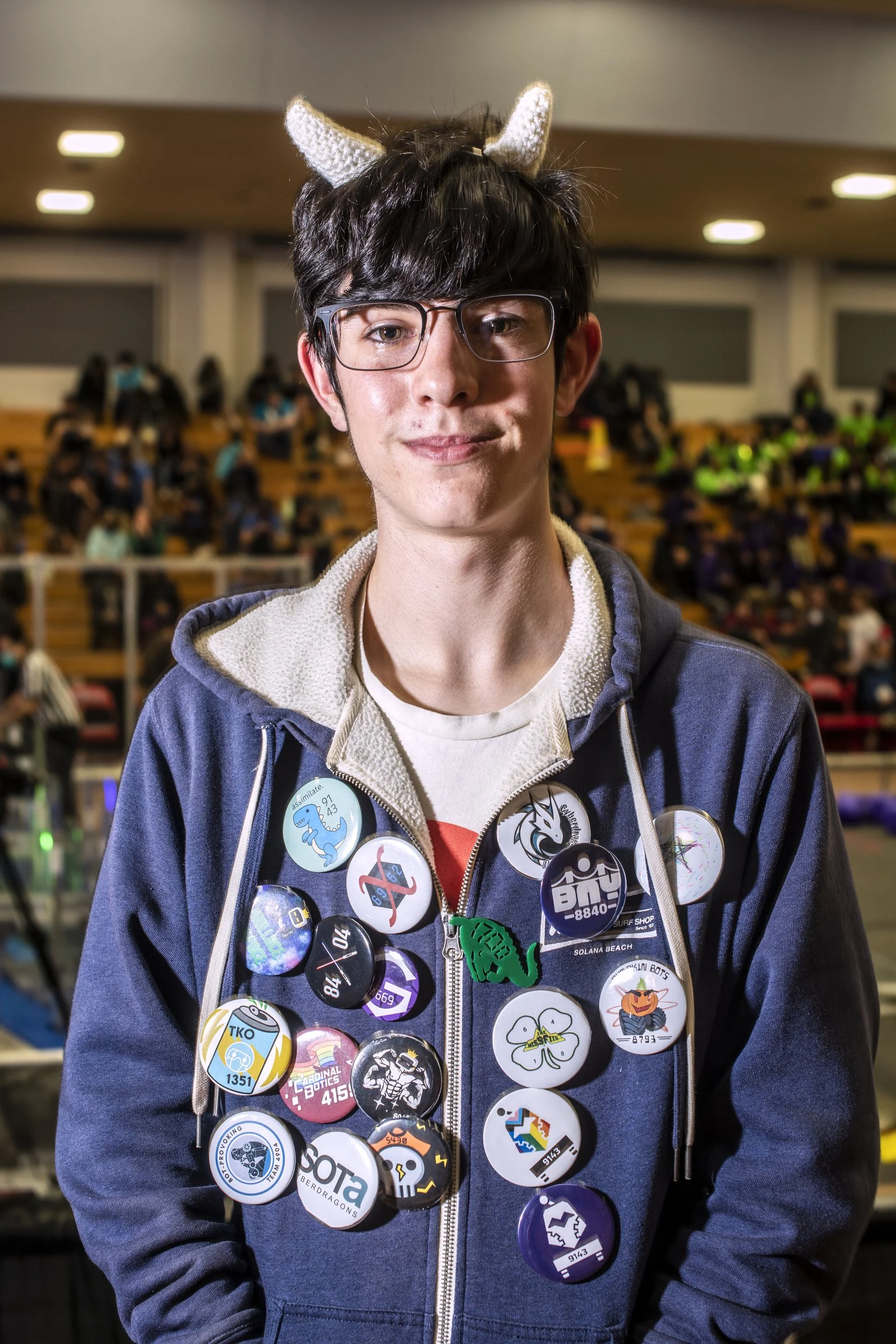  San Francisco, 2023.   Member of Ruth Asawa School of the Arts Cyberdragons Robotics Team wear buttons collected from other competing teams at San Francisco Regional tournament 