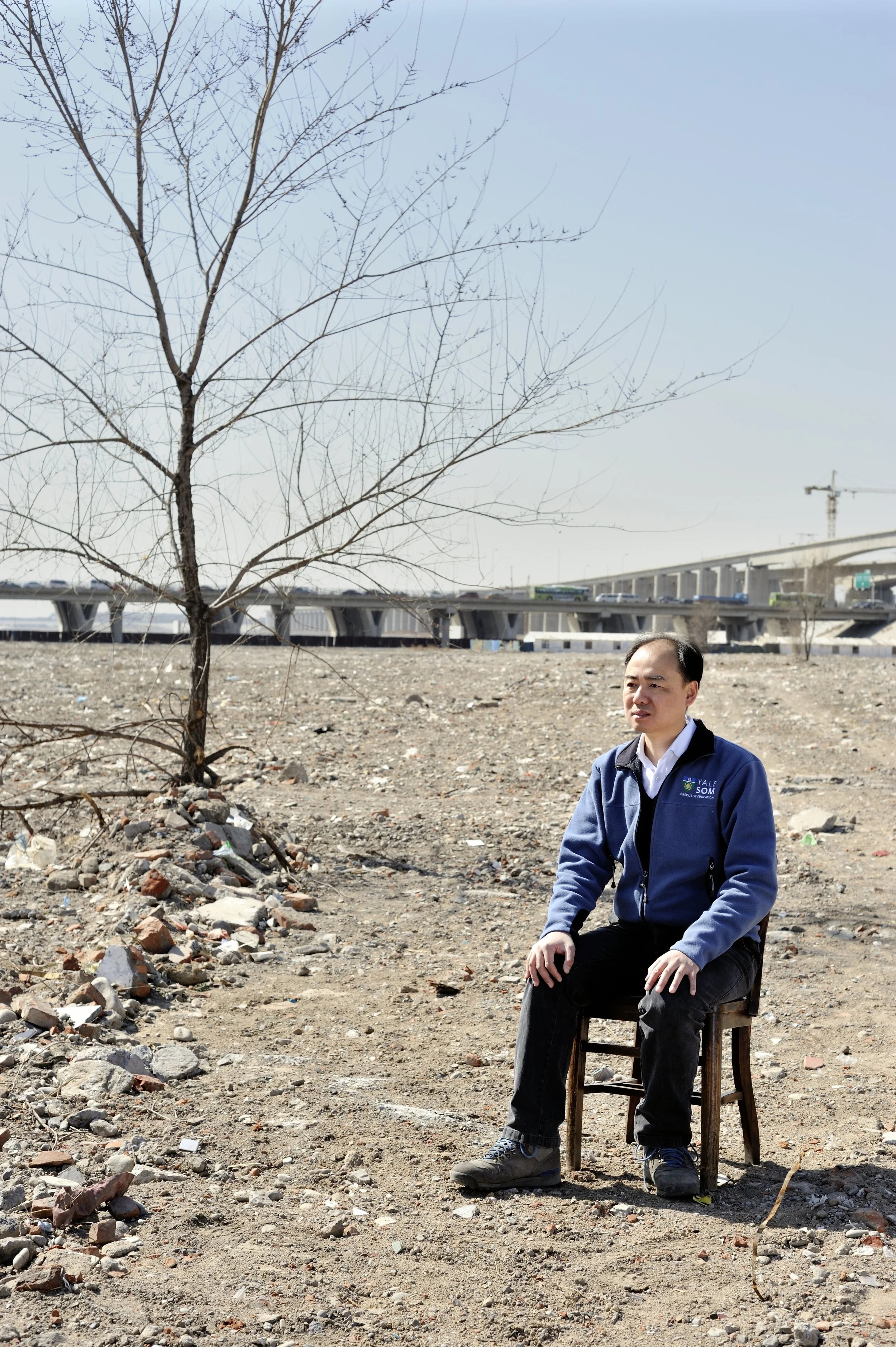  Ma Jun, director of the Institute of Public & Environmental Affairs.  Photographed in the dry riverbed of the Yongding River.  When he sees a willow tree incongrously budding in the litter strewn dust, he goes to look at it, saying "Seeing even this