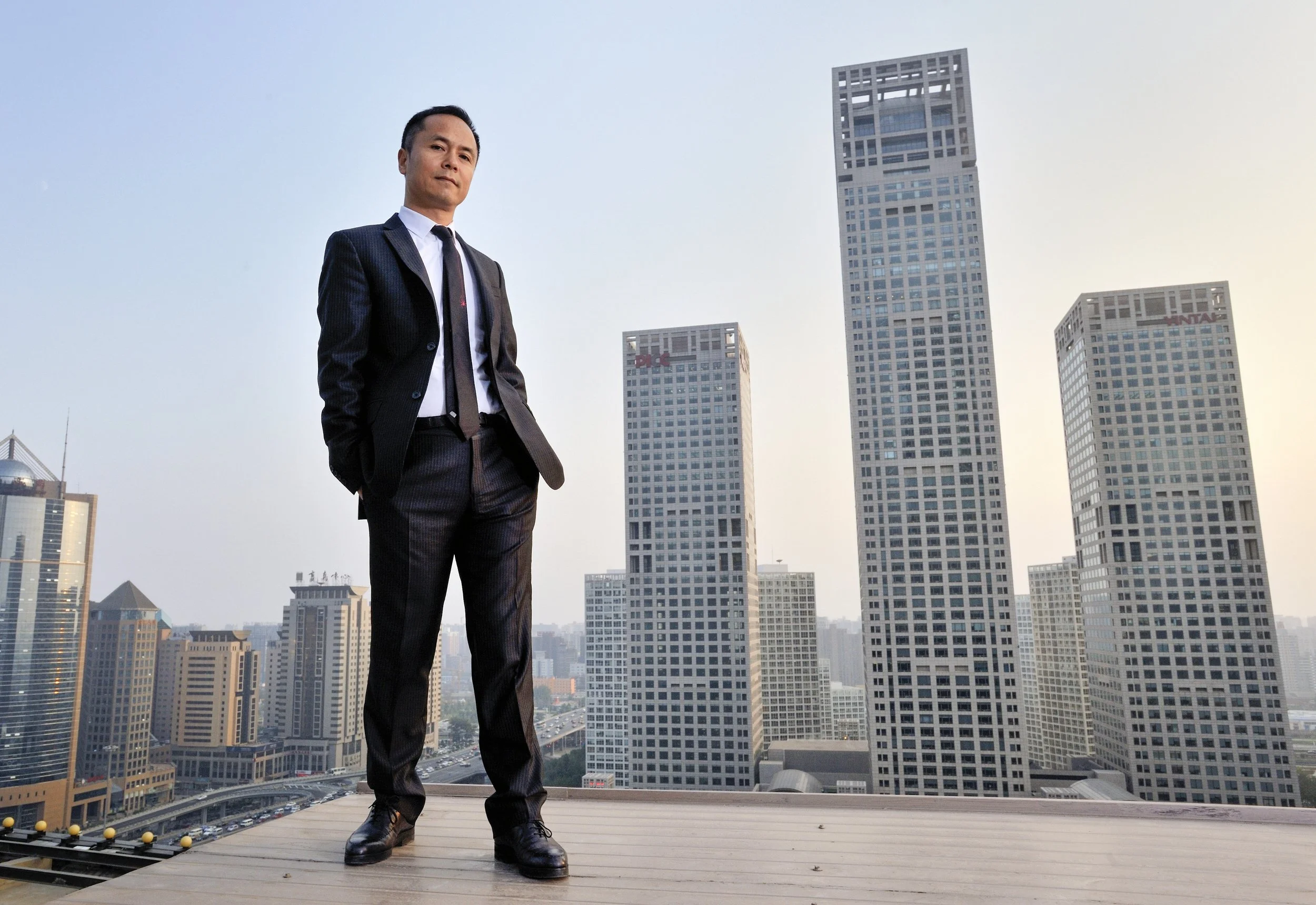  China Yin Tai Holdings, Co., Ltd chairman, Shen Guojun, in front of the company headquarters at the Yintai Center towers. 