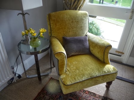 A vase of gold freesias to complement the gold velvet chair