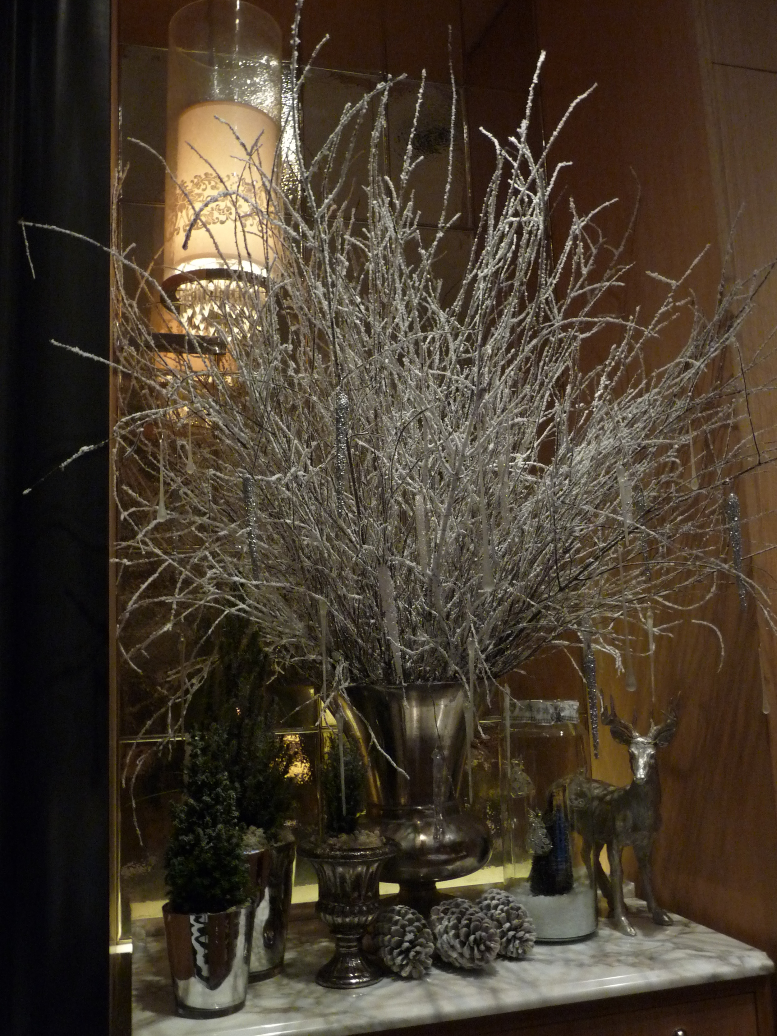  Beautiful Christmas arrangements of natural twigs sprayed white with decorations hanging from them 