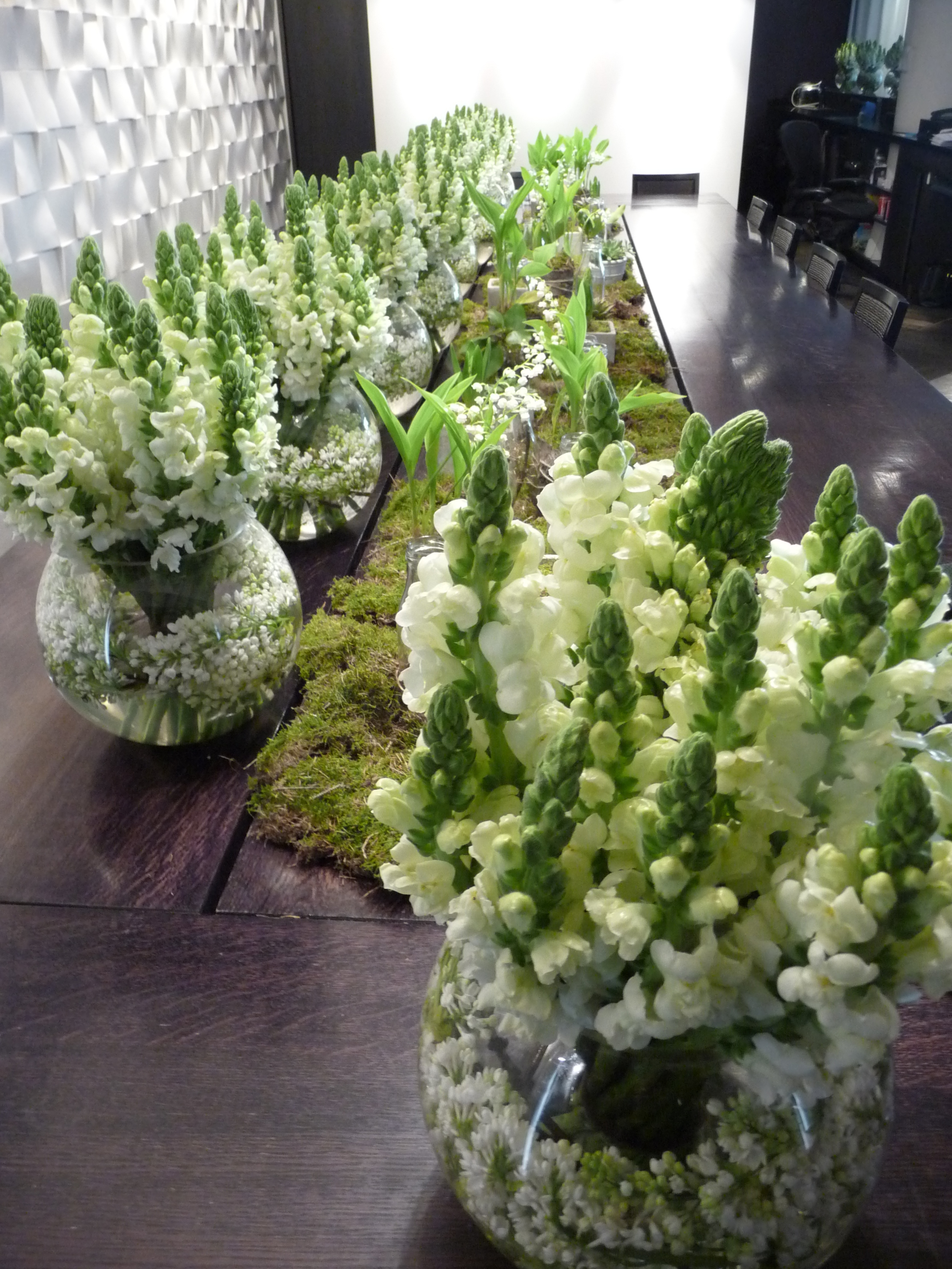  This long table display of flowers is absolutely amazing. White lilac is wrapped around&nbsp;the inside of each vase. There were small&nbsp;jars with succulent plants in them.&nbsp;One colour arrangements are always more impactful&nbsp; 