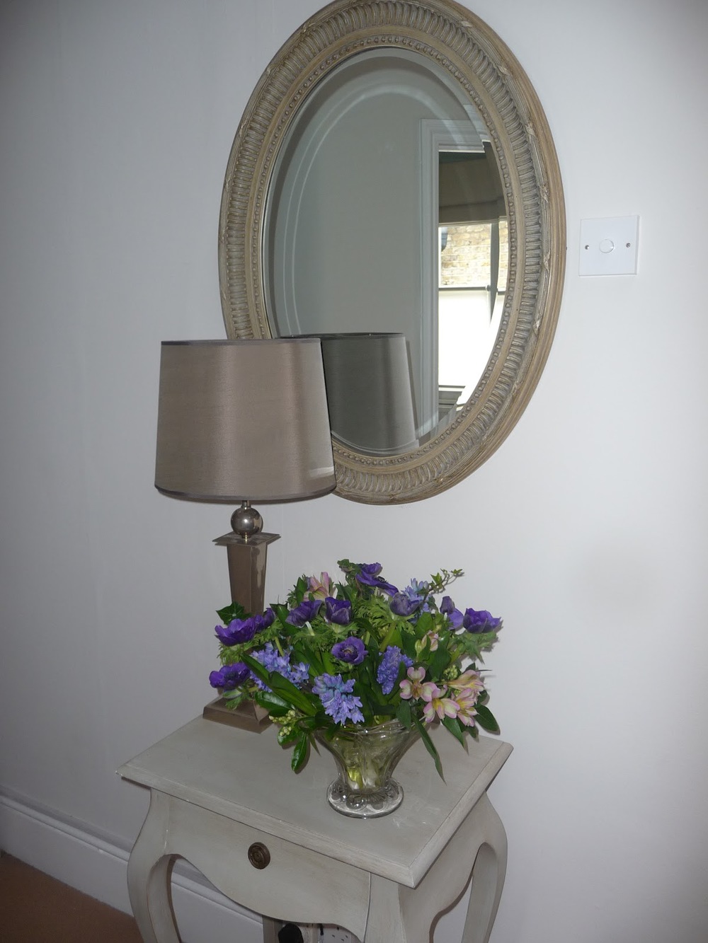 This mirror is made from bamboo and sits in the hall. I have created a focal point with the table, light and flowers