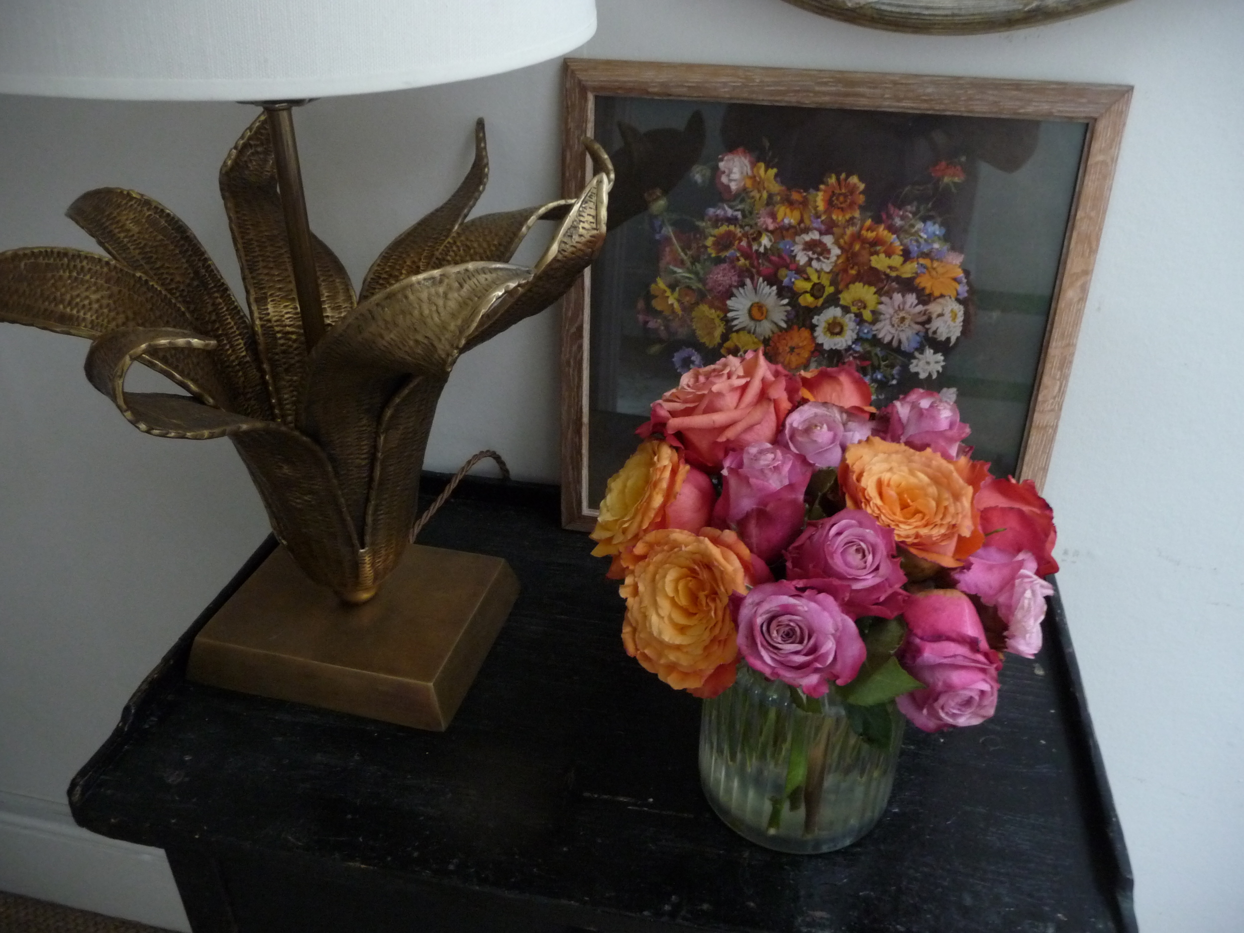  In my hall I have this vase of pink and orange roses which I've cut very short and crammed into this glass jar/vase.&nbsp; Roses last much longer if cut very short. I chose these two colours to complement the 60s flower print that sits behind. 