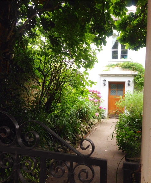 A peek through the gate into someone's pretty garden