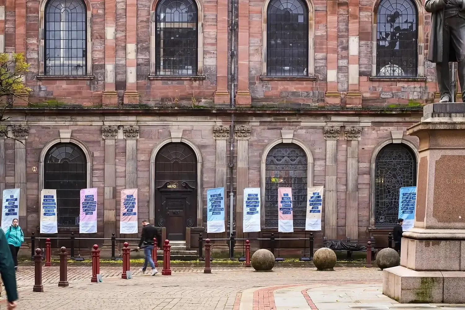 Public installation The Belonging Project, presented in front of the church in St Ann’s Square, Manchester.

The work features flags illustrated with text drawn from anonymous public submissions exploring the theme of belonging during periods of isol