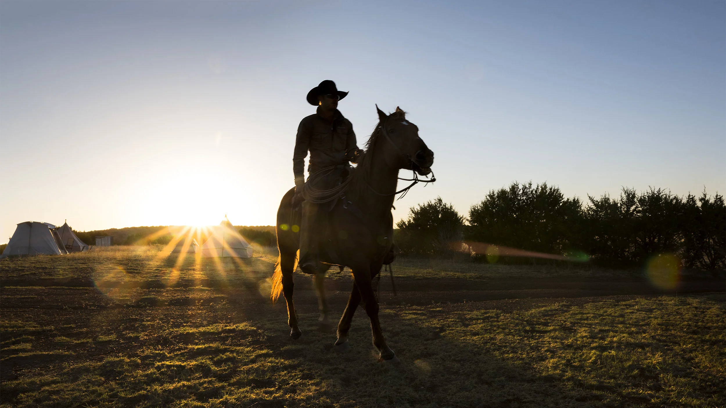 Sunrise over cowboy on horseback at cowboy camp, Spring roundup,