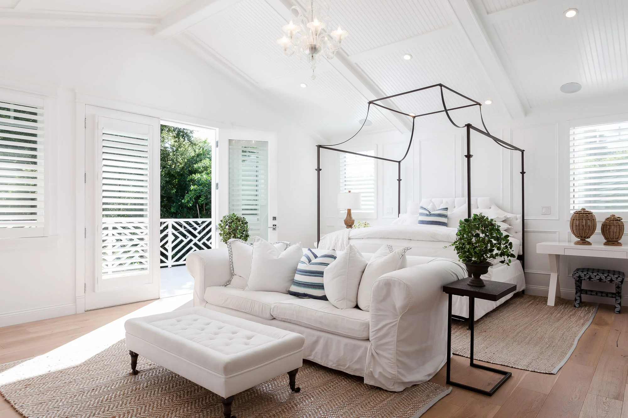 Bright and airy bedroom in Sherman Oaks, California with white furniture, canopy bed, and natural light streaming through large windows.