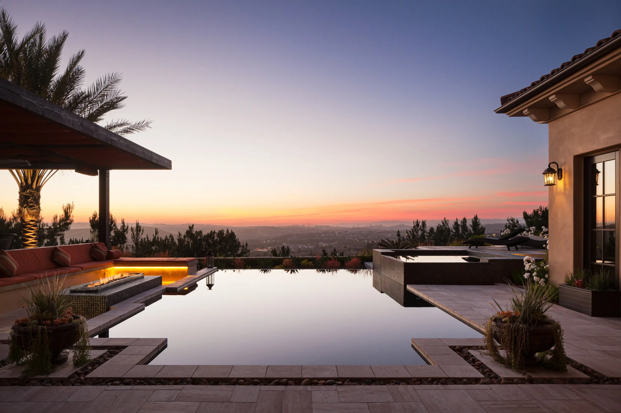 Luxury home with infinity pool at sunset in Orange County, California.