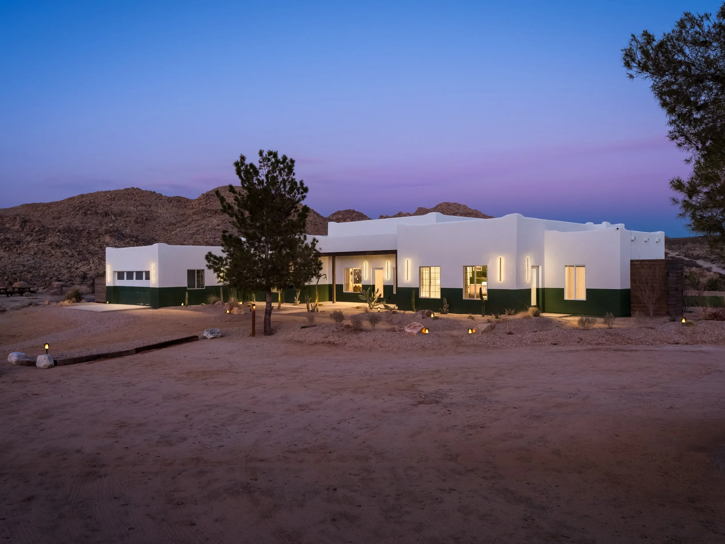 Modern exterior of the Joshua Tree Country Club in Joshua Tree, California, surrounded by desert landscape at dusk.