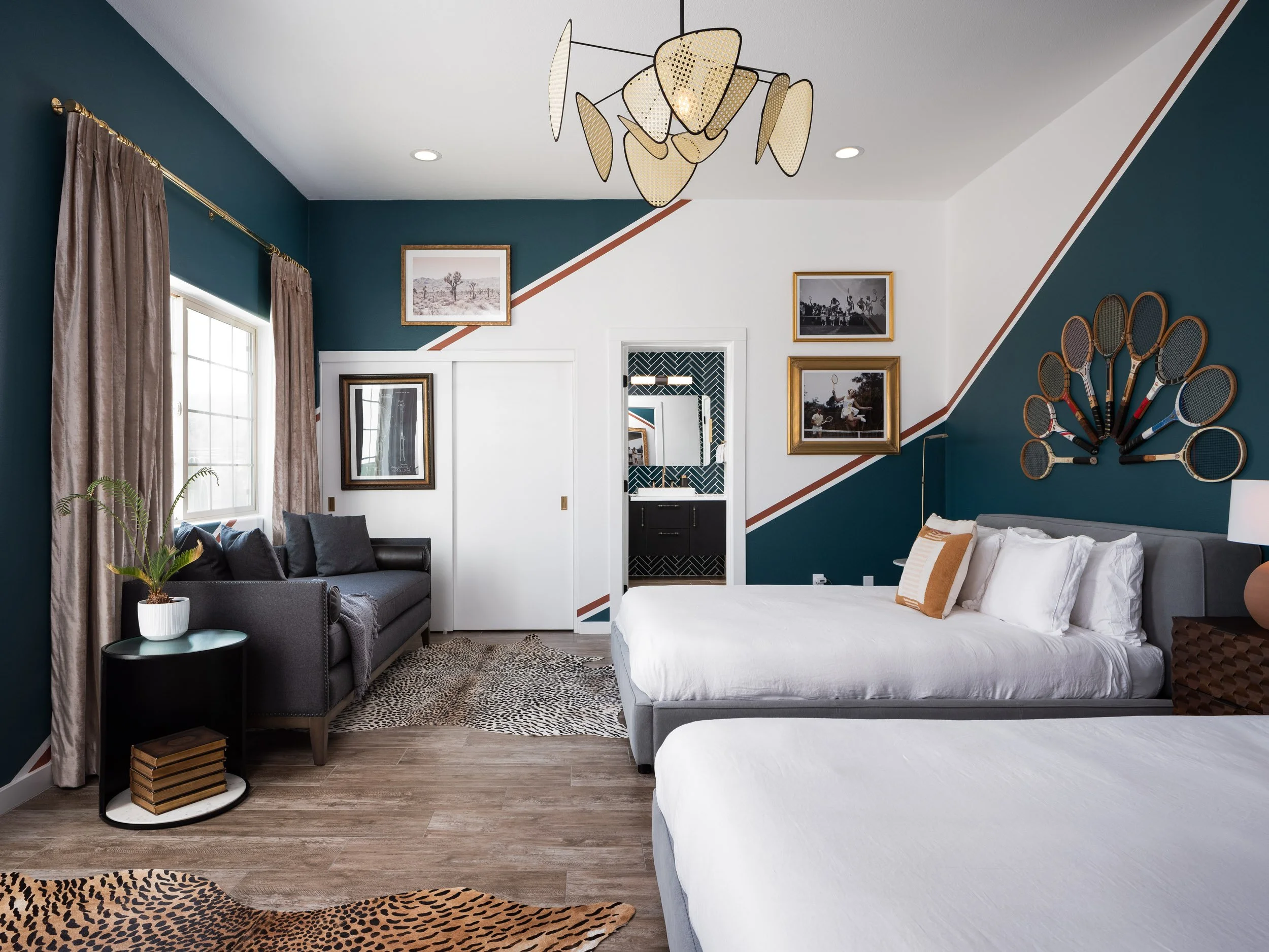 Modern interior design of the Tennis Suite bedroom at the Joshua Tree Country Club in Joshua Tree, California, featuring contemporary decor, unique wall art, and elegant furnishings.