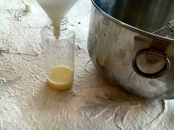 Using my funnel to pour the wash while it is still runny into the container.