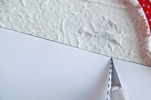 Here I am using the exacto knife to score the dashed line. You only want to make a light crease being careful not to cut through the whole card.  This will make it easier to fold the card.