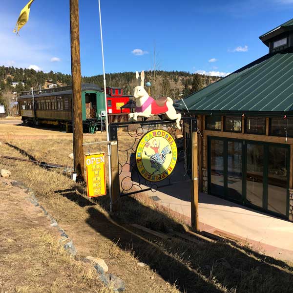 The sign from the street. The structure to the right is the building that houses the carousel and off the left is an old train car/coffee shop in the charming town of Nederland.