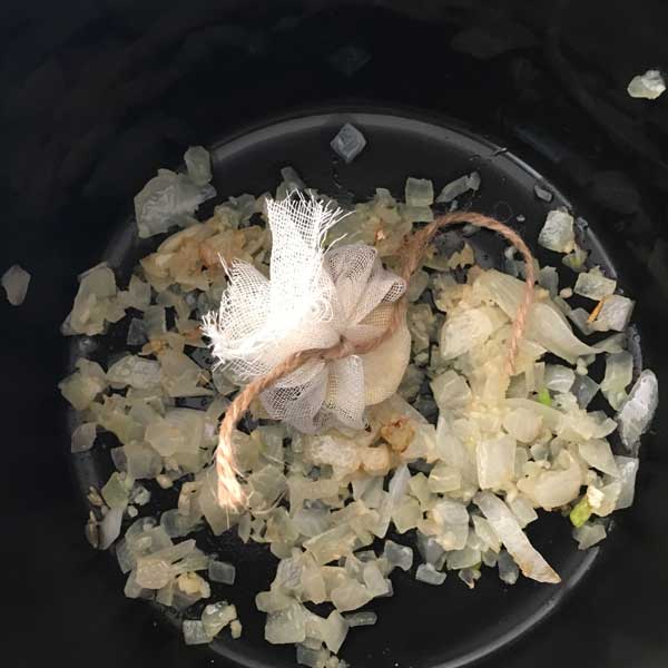 Here I have transferred the onion, garlic, and spice packet into the crockpot.