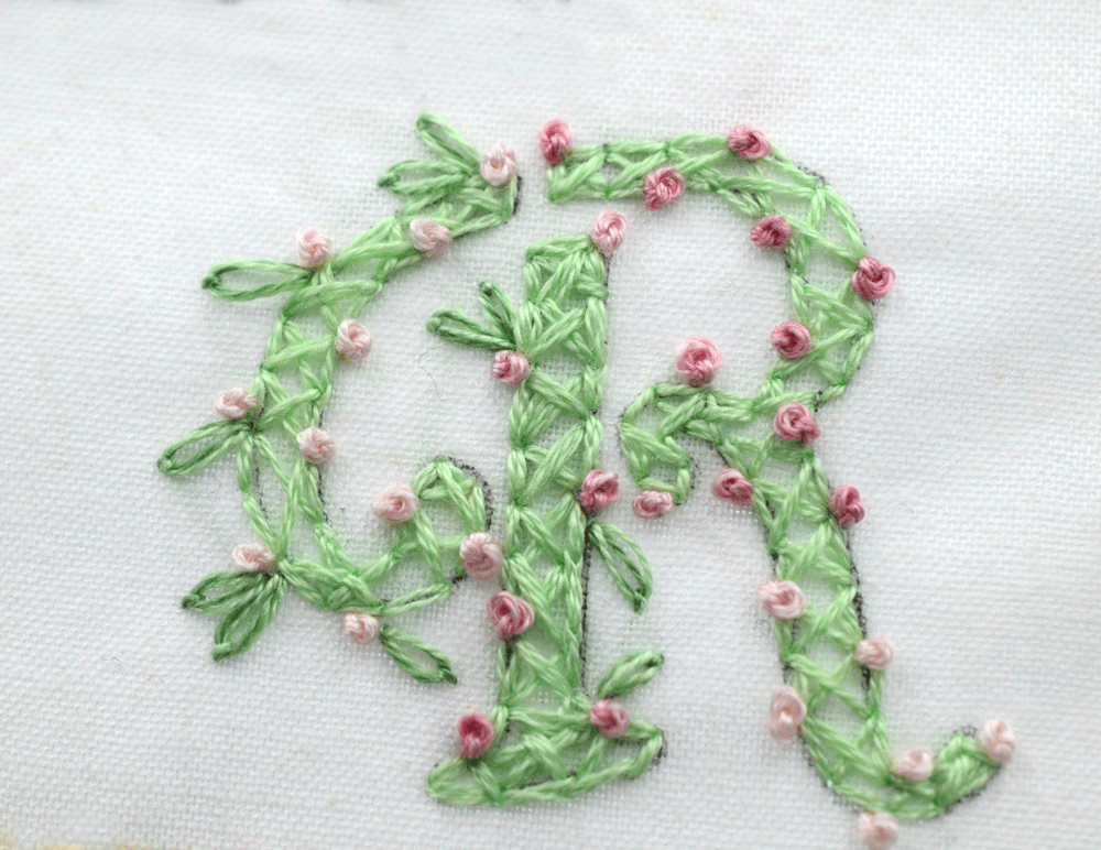 In the above example, I add a criss-cross design inside the lettering. I then add LAZY DAISY stitch to create petals and FRENCH KNOTS to resemble tiny rosebuds. This was inspired by the floral lettering I reference above.