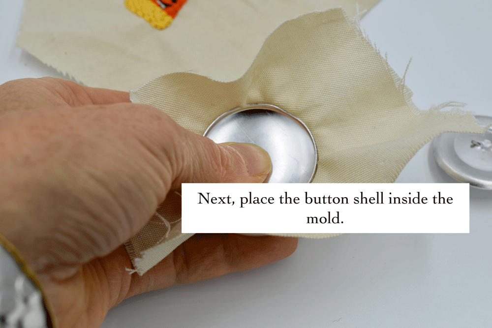 The instructions on the button maker has a pattern on the back to trace the perfect sized circle to fit around your button with just enough overlap but for some reason it wasn’t enough overlap for me. I was wondering if it had something to do with the embroidery. I decided to trim the fabric after I fitted it into the mold and around the button.