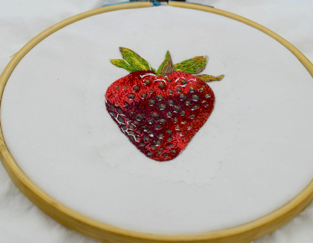 I dug into this project without ever stopping to take progress shots! Sometimes the passion overtakes me and I just forget to stop what I am doing to take pictures. I started with the lighter red at the top of the strawberry. I then realized it would be easiest to fill in all the seeds rather than leave them empty and try to sew around them. The seeds had several different colors so that kept me busy for quite a while! Once the seeds were finished, I added the red background. There were shades of pink, crimson, coral, and orange. I just kept looking at the photo and painting for color and value reference.