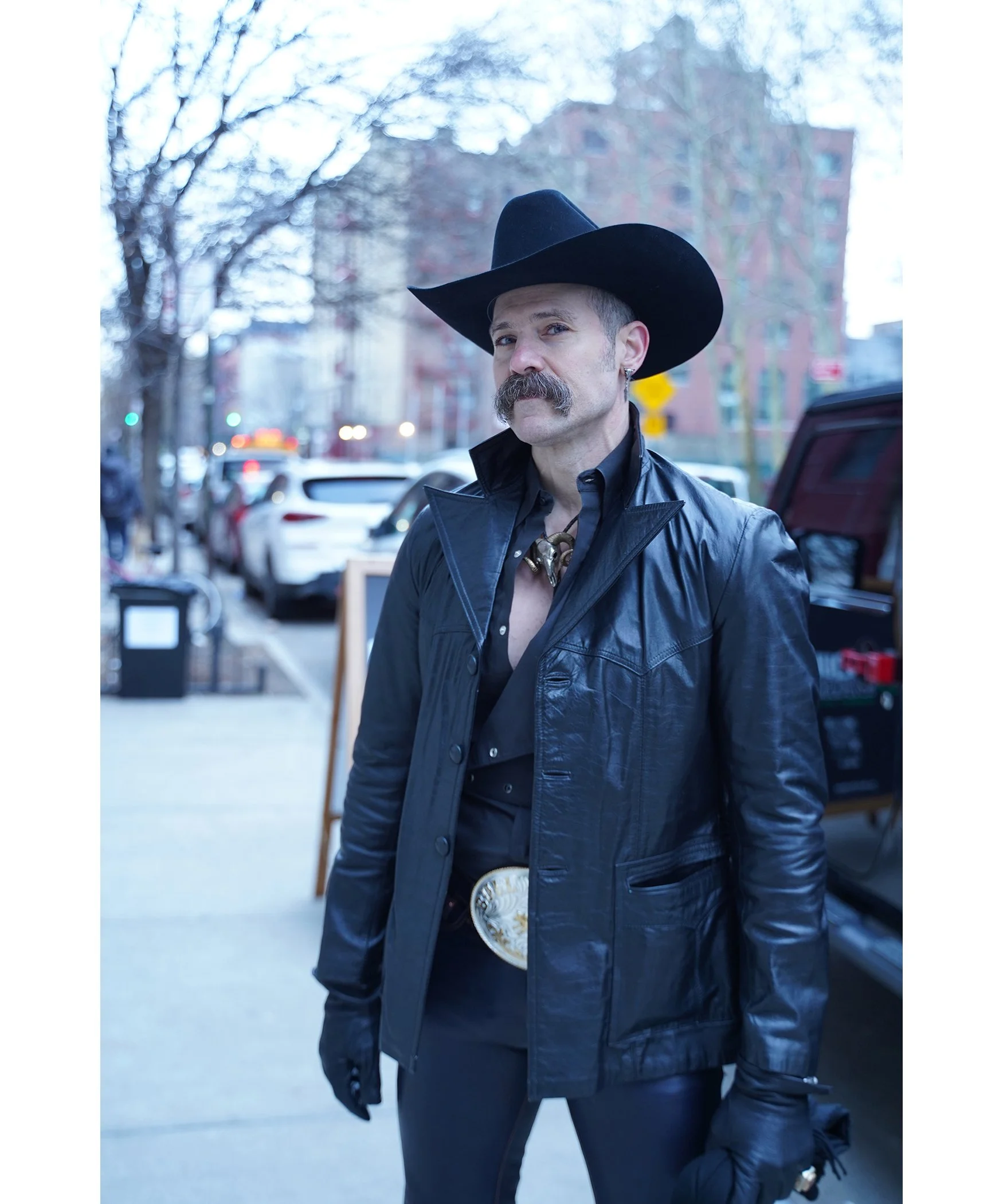 This is my first street photo! Taken on February 14, 2024 outside a Basquiat exhibit. The unidentified man hides a smile under his handlebar moustache. I saw it when I zoomed in close.