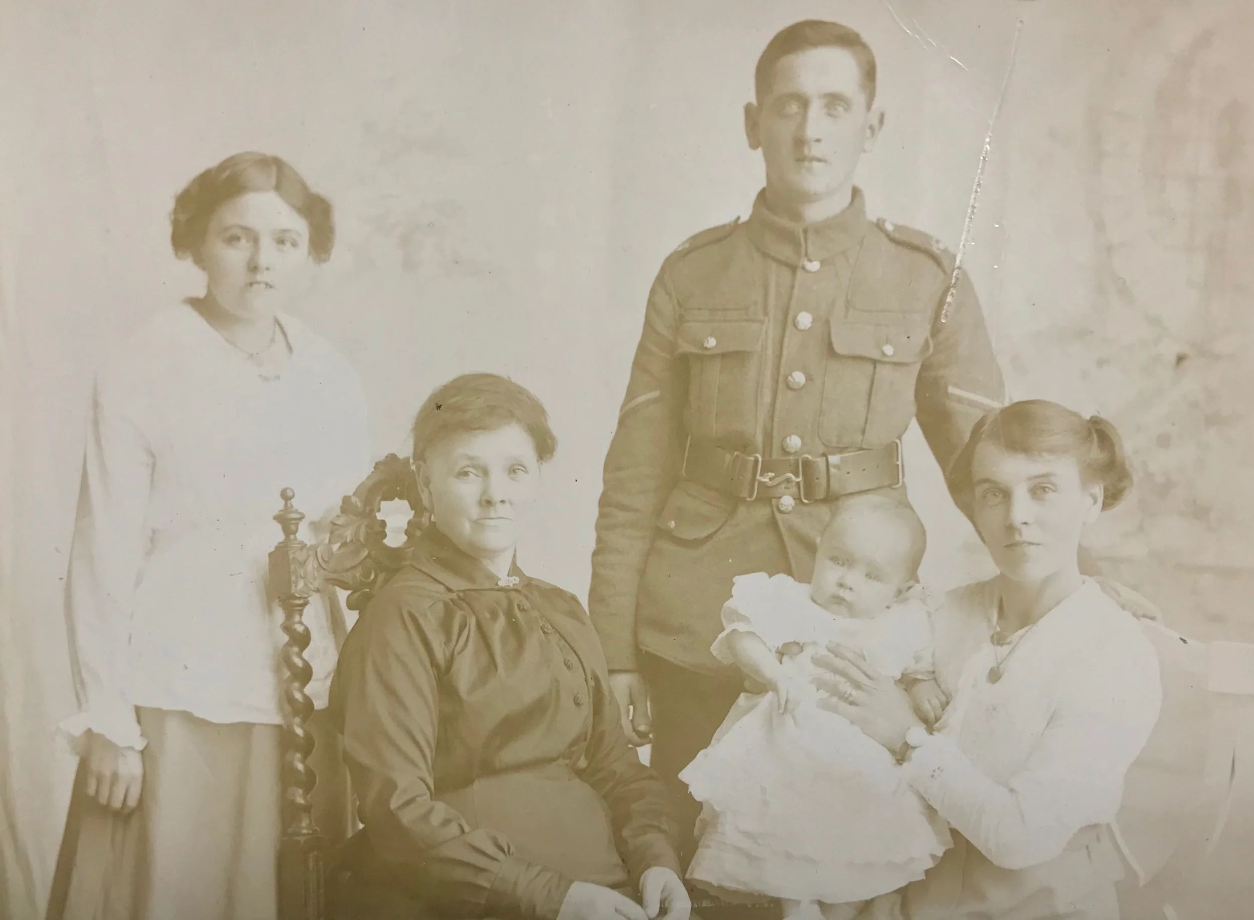 Photo 1915 - Bertram’s wife Maud sitting with baby Evelyn, Maud’s mother also sitting and her younger sister Florence.  Bertram wearing a Lance Corporal’s stripe.