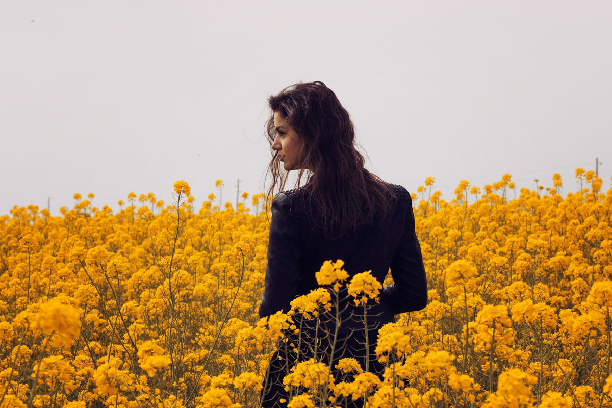 Model in a field of yellow flowers