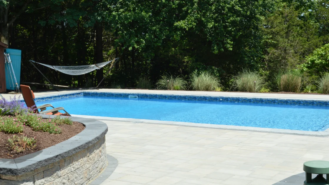 Natural Stone and Greenery for a Welcoming Poolside Atmosphere