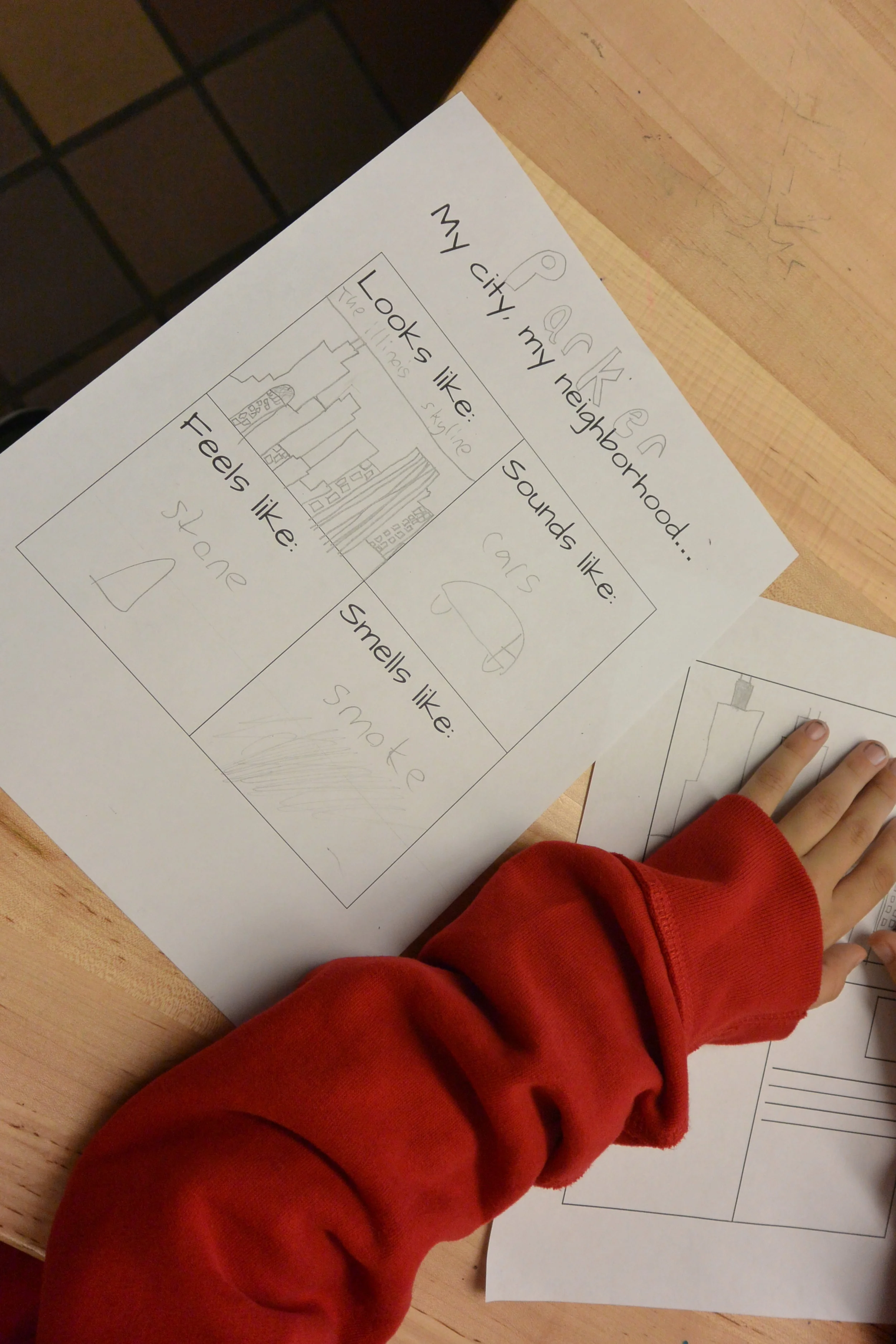  A student works on a sketch handout to design their postcard. 