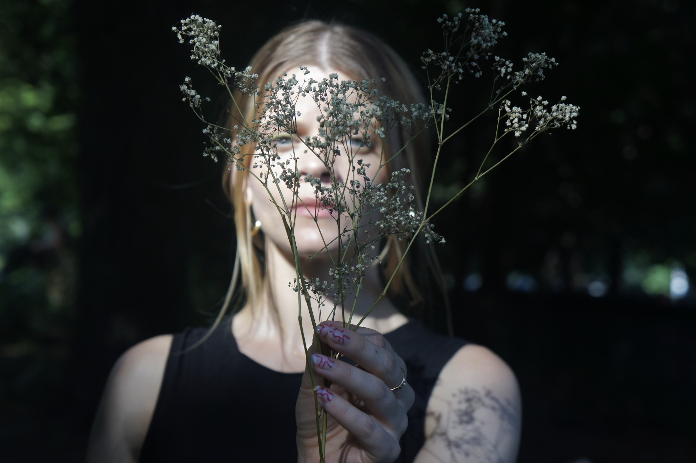 Laura Cocks flute photograph in the park with dark shadows with flowers