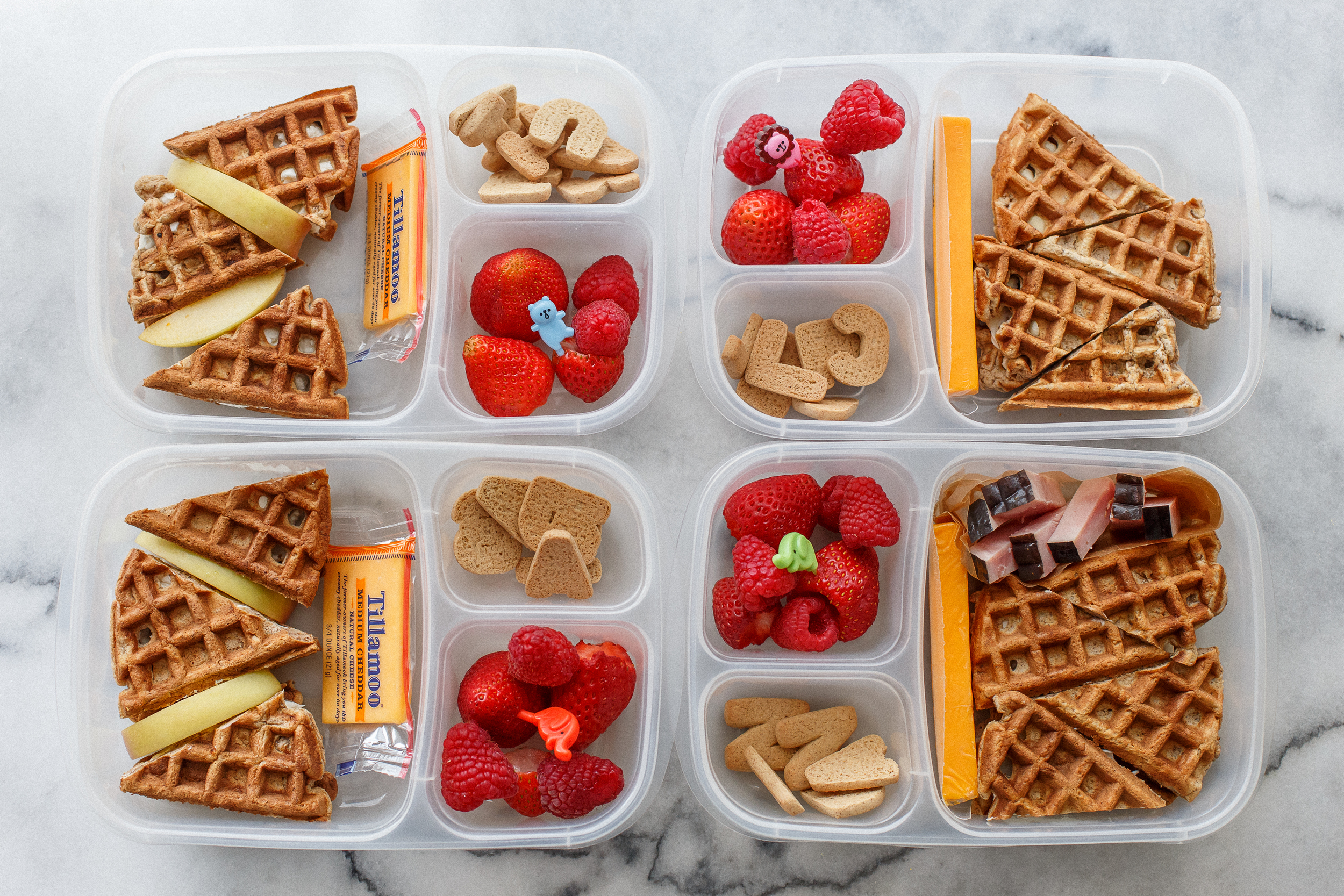 Wednesday is breakfast for lunch day at our house, and it's often the most popular lunch of the week. This one was no exception. Waffle sandwiches! Homemade waffles, I used whole wheat flour, oats, ground flax, extra egg, homemade almond milk, and just a little sugar - so they're pretty healthy. Three are spread with cream cheese, and one child has butter. They also have a cheddar cheese, berries, and some little cinnamon letter cookies to spell our their name. The boy has a little ham, and two of the girls have a couple slices of apple.