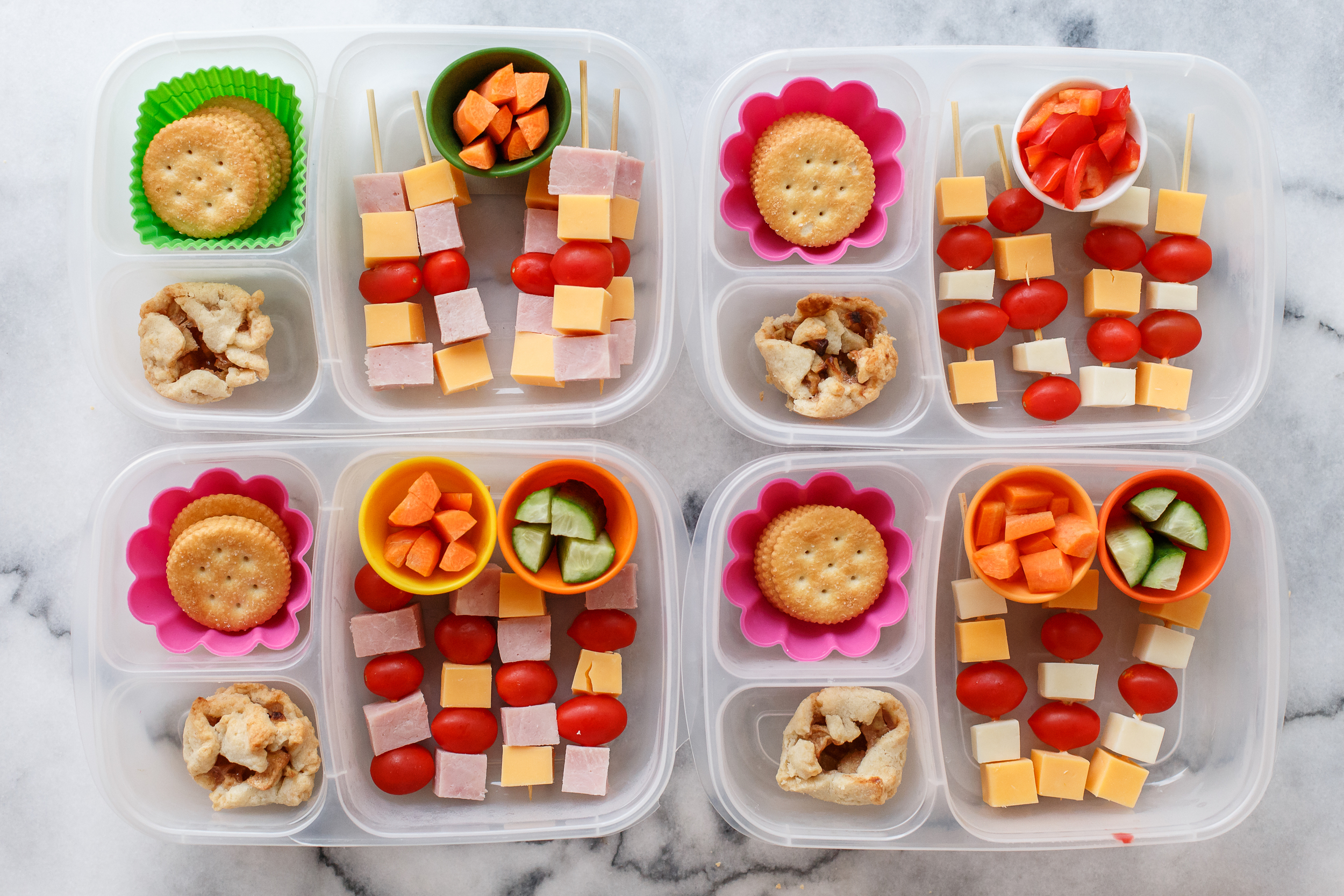 Little skewers of cheese and tomatoes, and ham for the meat eaters. Plus crackers and carrots, cucumbers for two, sweet peppers for one, and a mini apple pie for a special dessert treat!