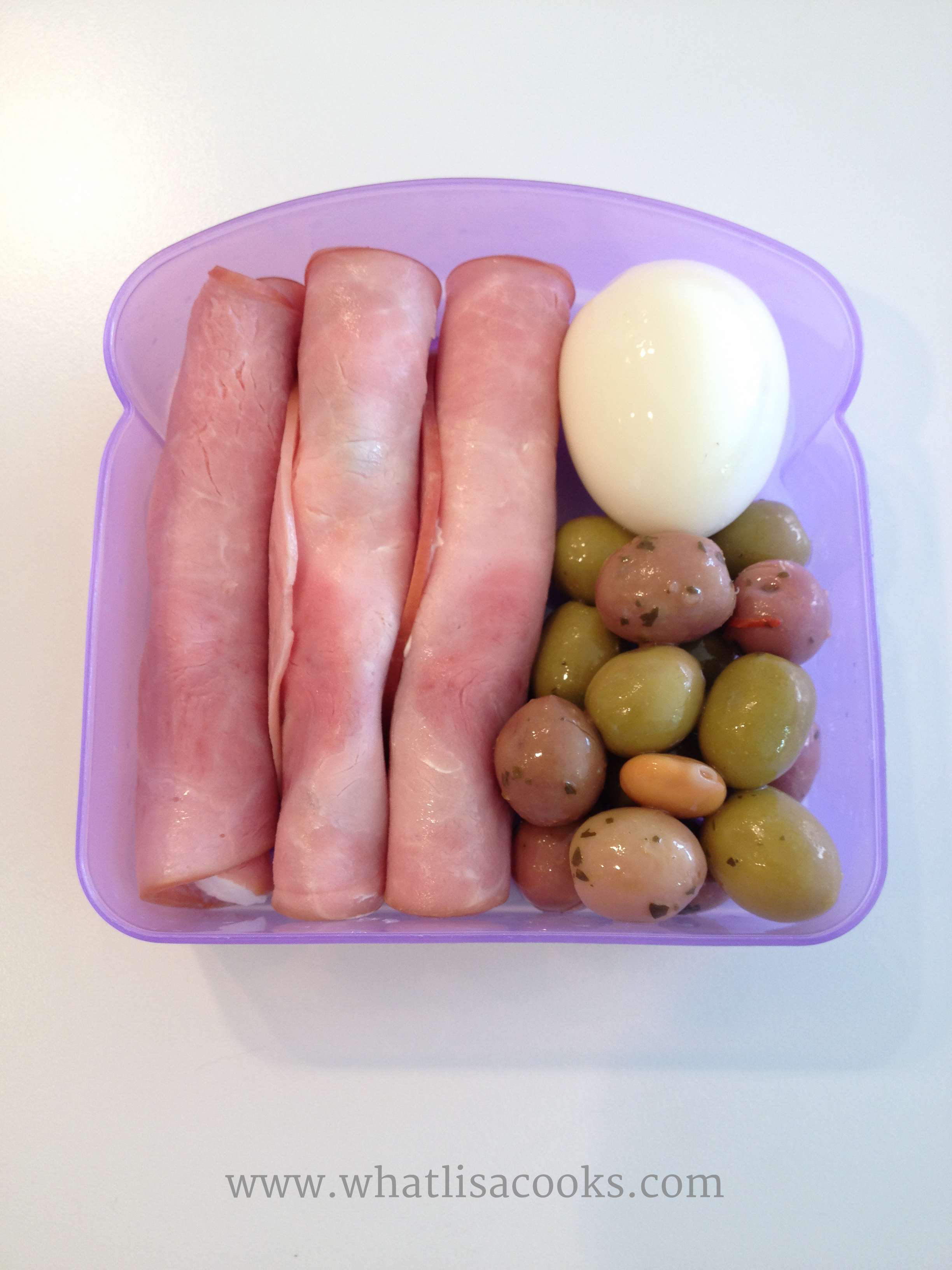 Little sandwich boxes are the perfect size for a small meal. This was a protein packed, low carb, power lunch. Slices of ham spread with cheese and rolled around a pickled asparagus, with boiled egg, marinated olives. 