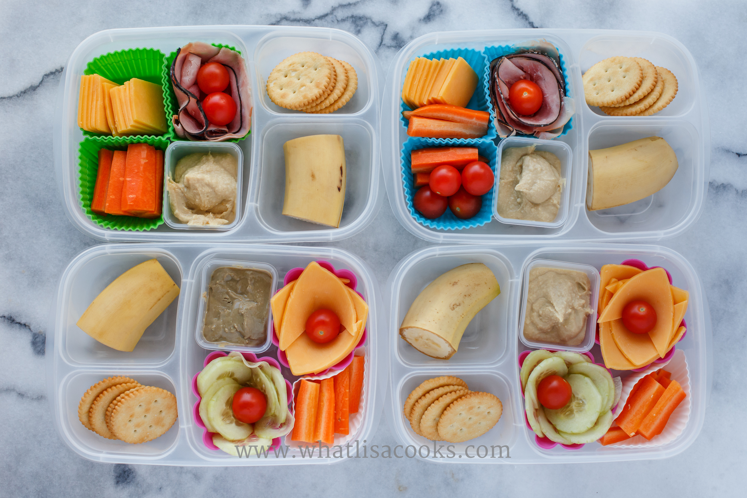 Cheese & cracker box. With hummus (one has sunbutter), carrots, tomatoes. Two have ham and two have cucumbers. 